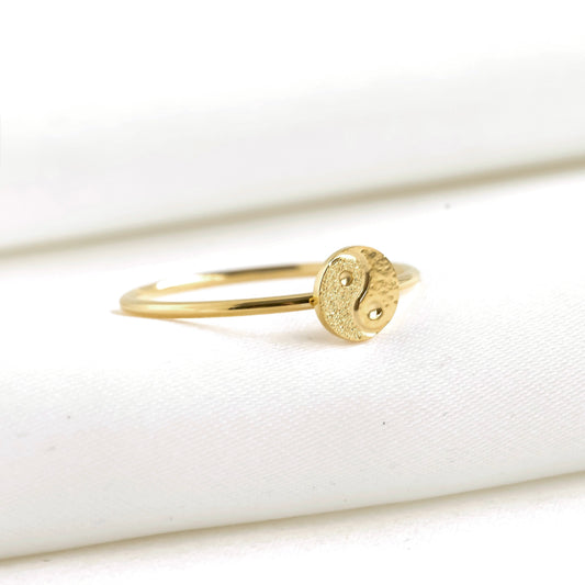 Gold ring with a yin yang symbol on a white background