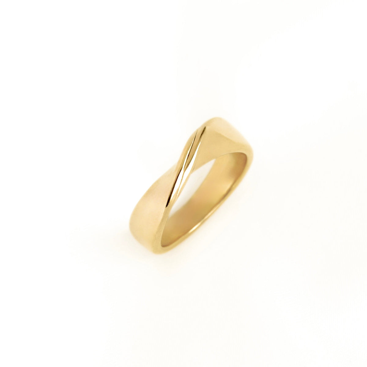 A wide gold band with a gentle front twist centered on a solid white background with a soft reflection below.