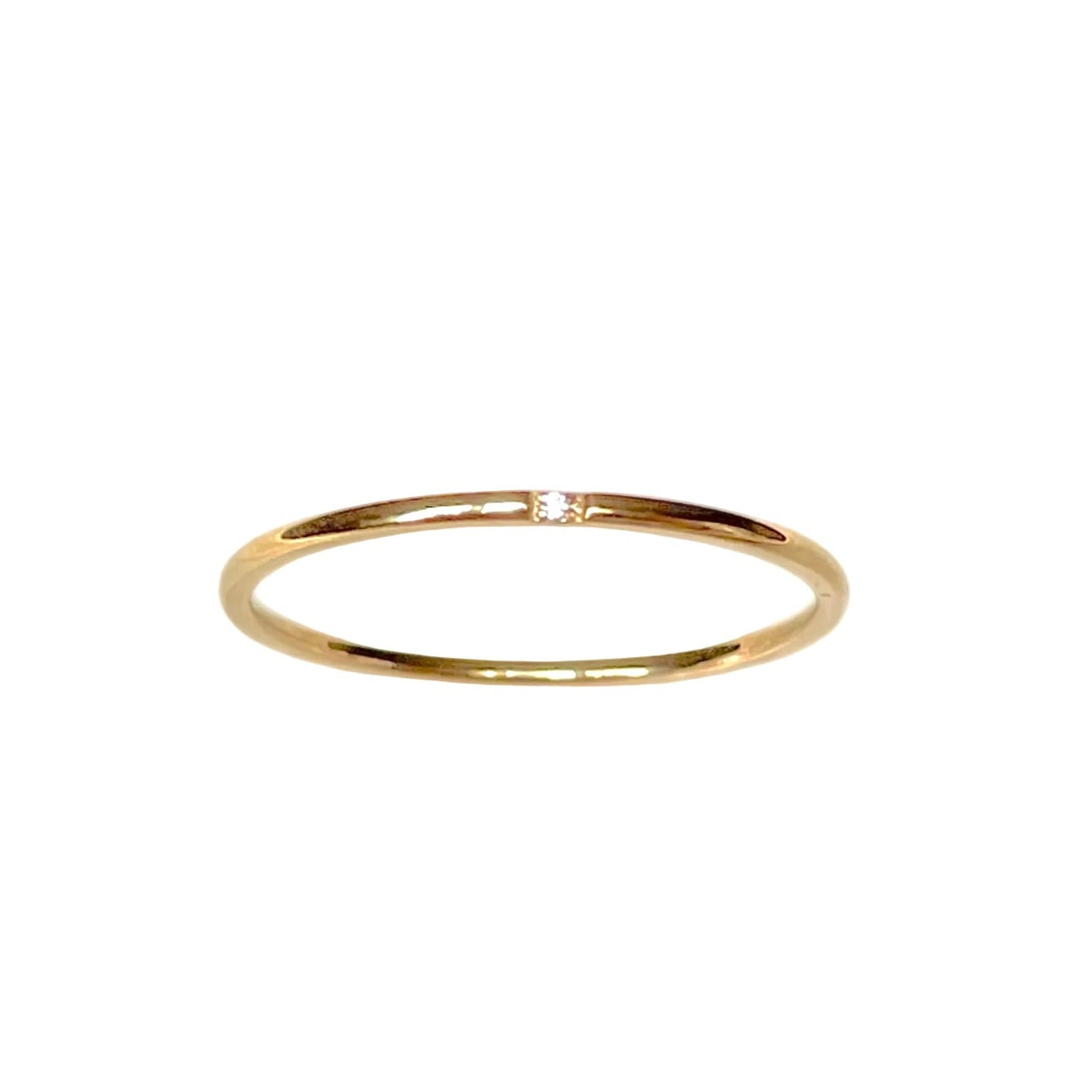 Top view of thin gold CZ ring on a white background