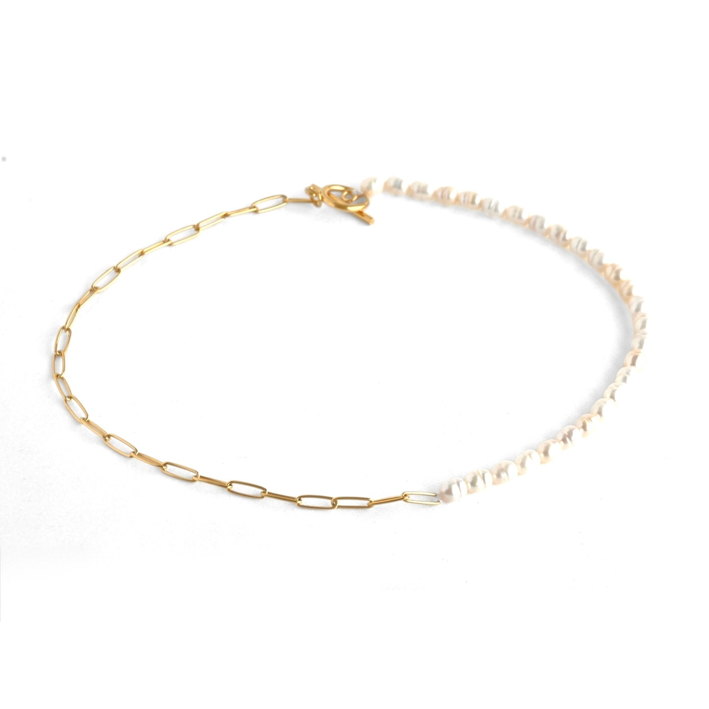 Half gold chain and half freshwater pearl necklace with a toggle clasp  on a white background