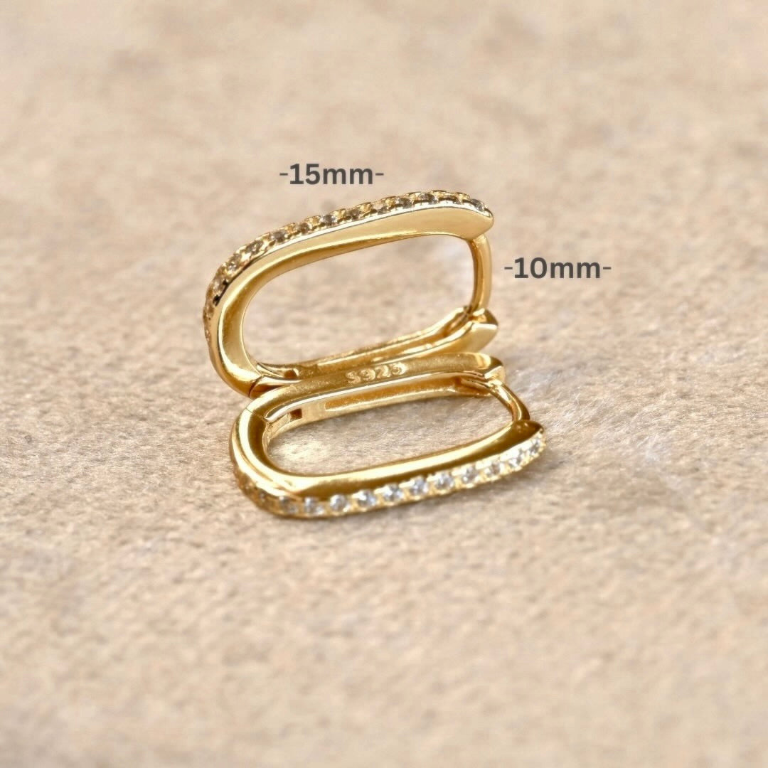 Gold rectangular earrings with 10x15mm measurement labels on a beige background