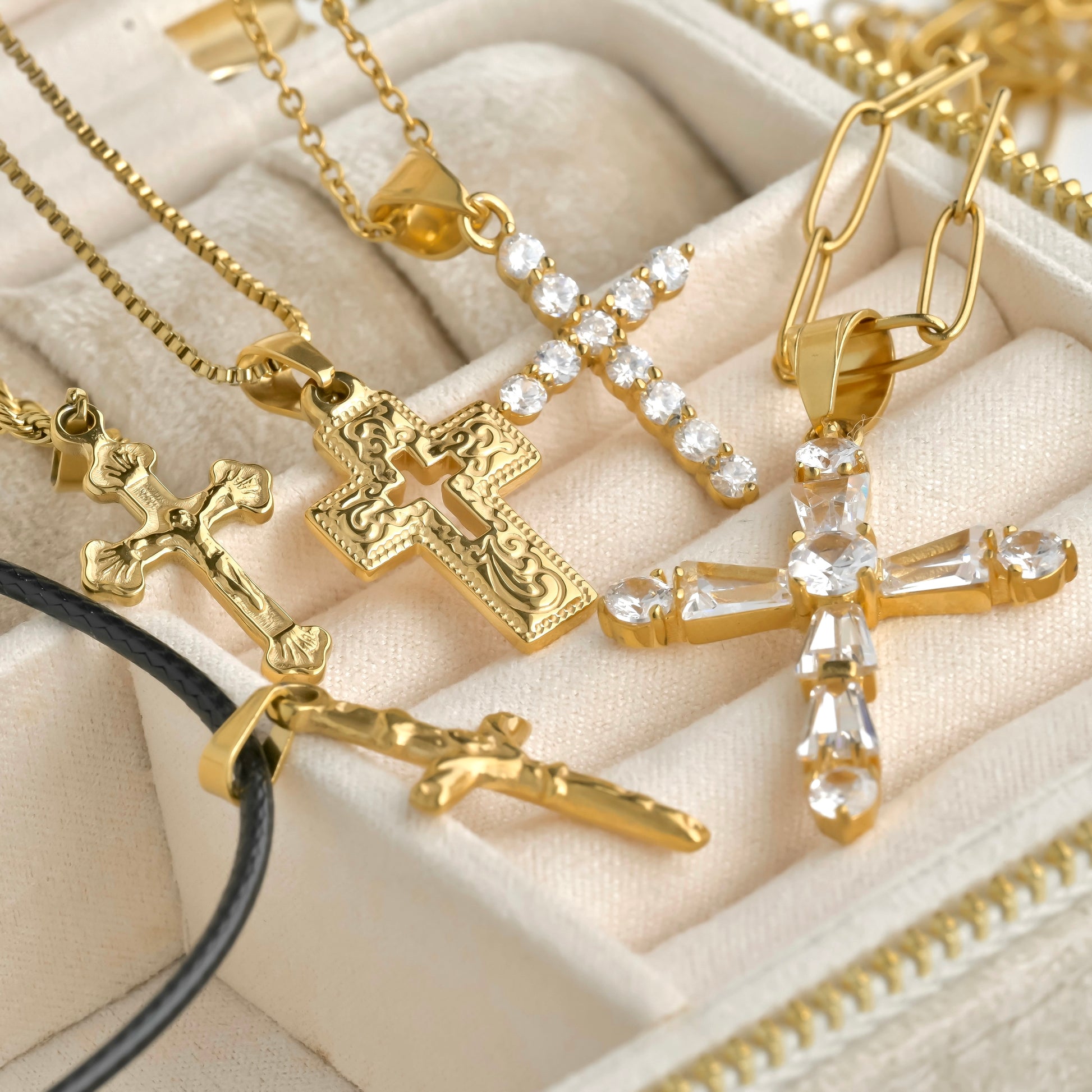 Personalized gold necklaces with cross pendants on a beige fabric background