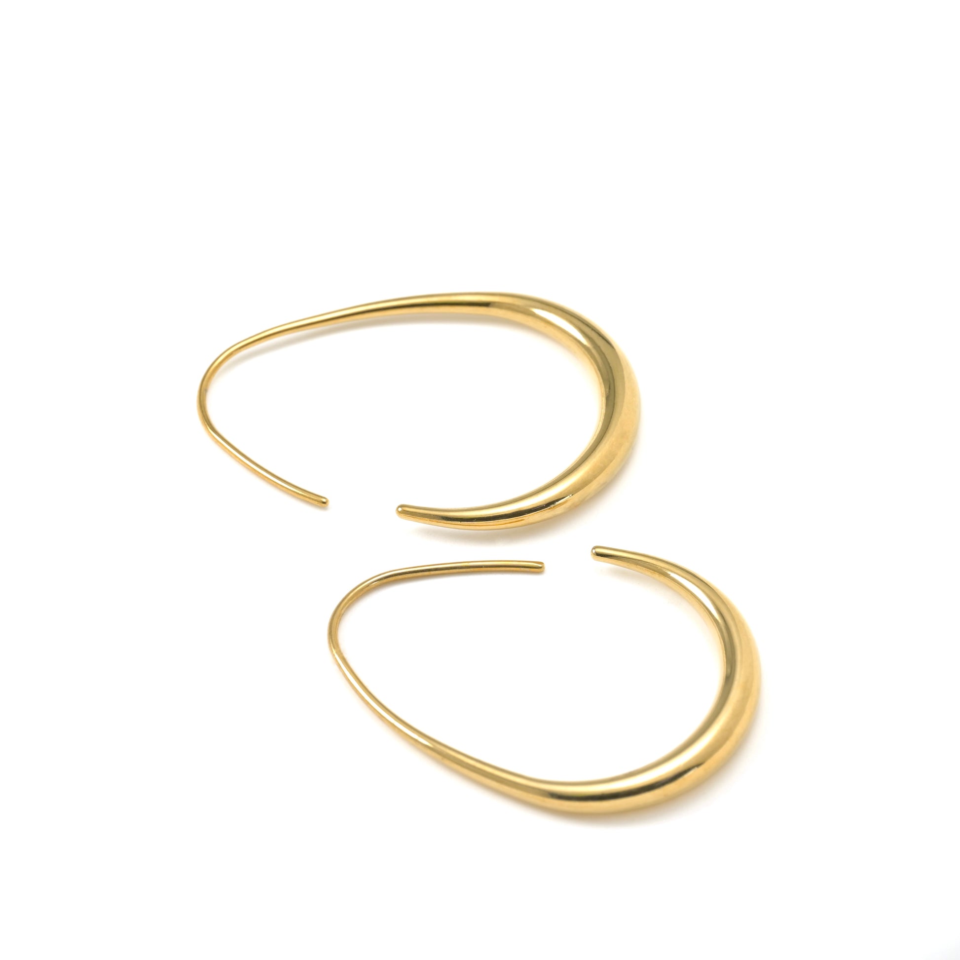 Side view of gold hoop earrings on a white background
