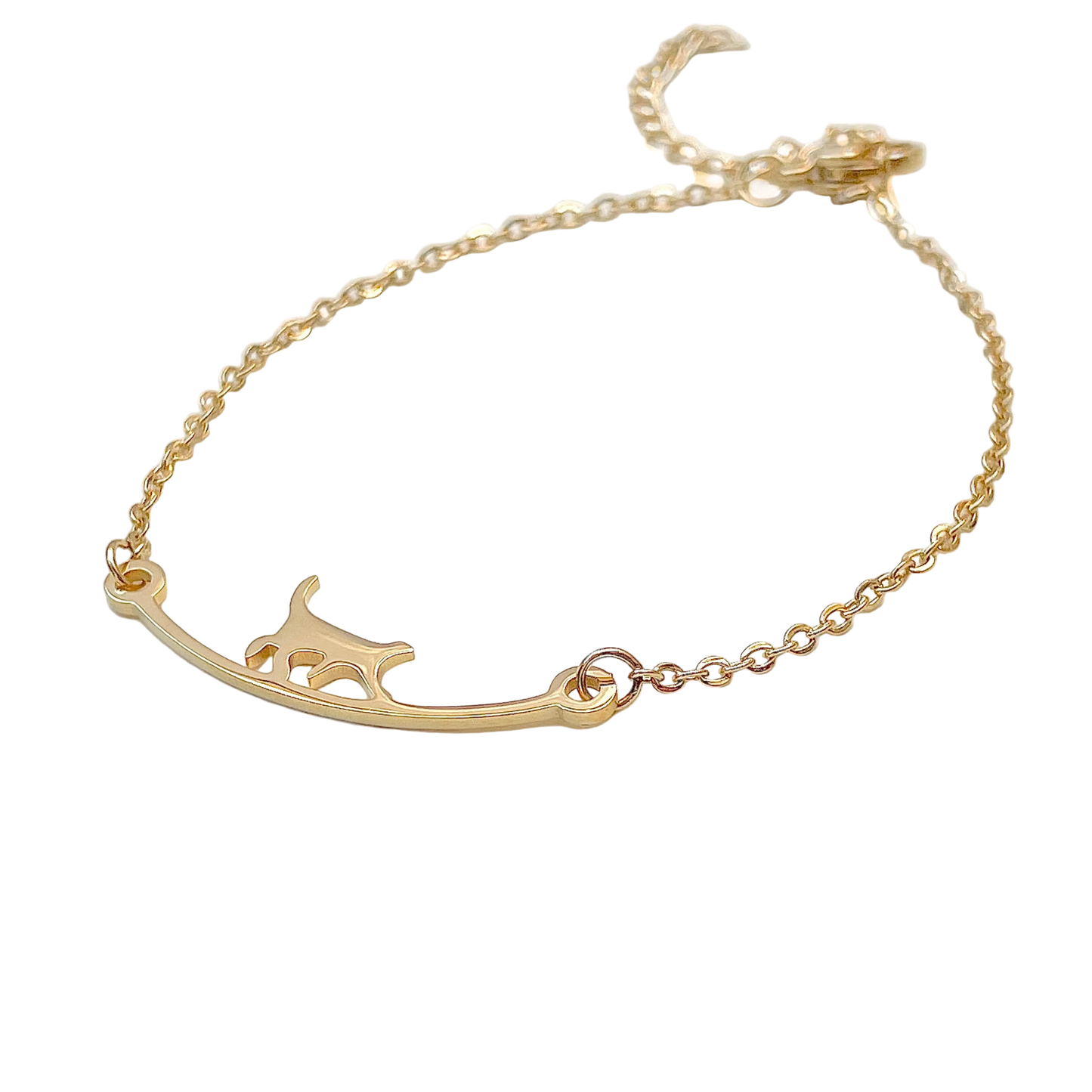 Gold bracelet with a curved bar and a cat silhouette on a white background