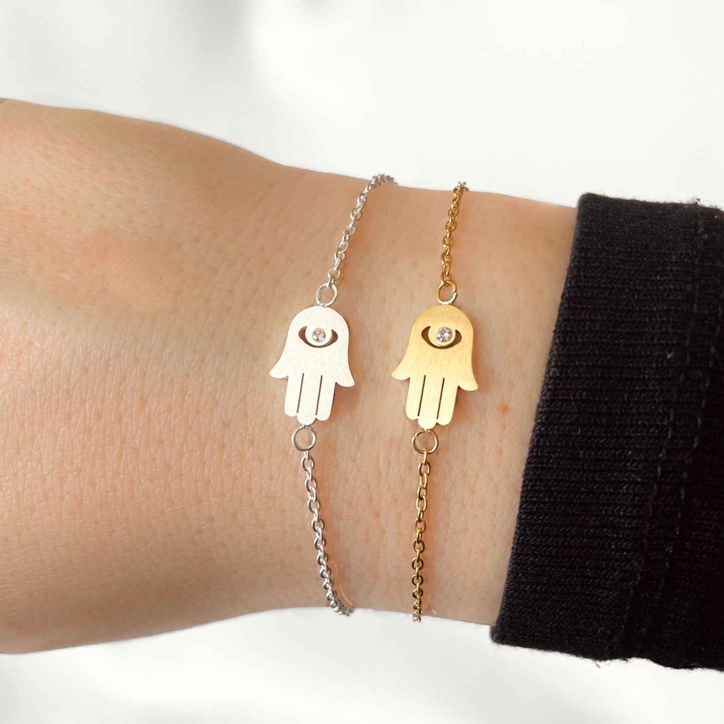 Two hand-shaped bracelets on a wrist against a white background