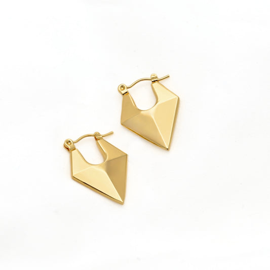 A pair of gold geometric hoop earrings with faceted, angular triangular charms, displayed on a clean white background.