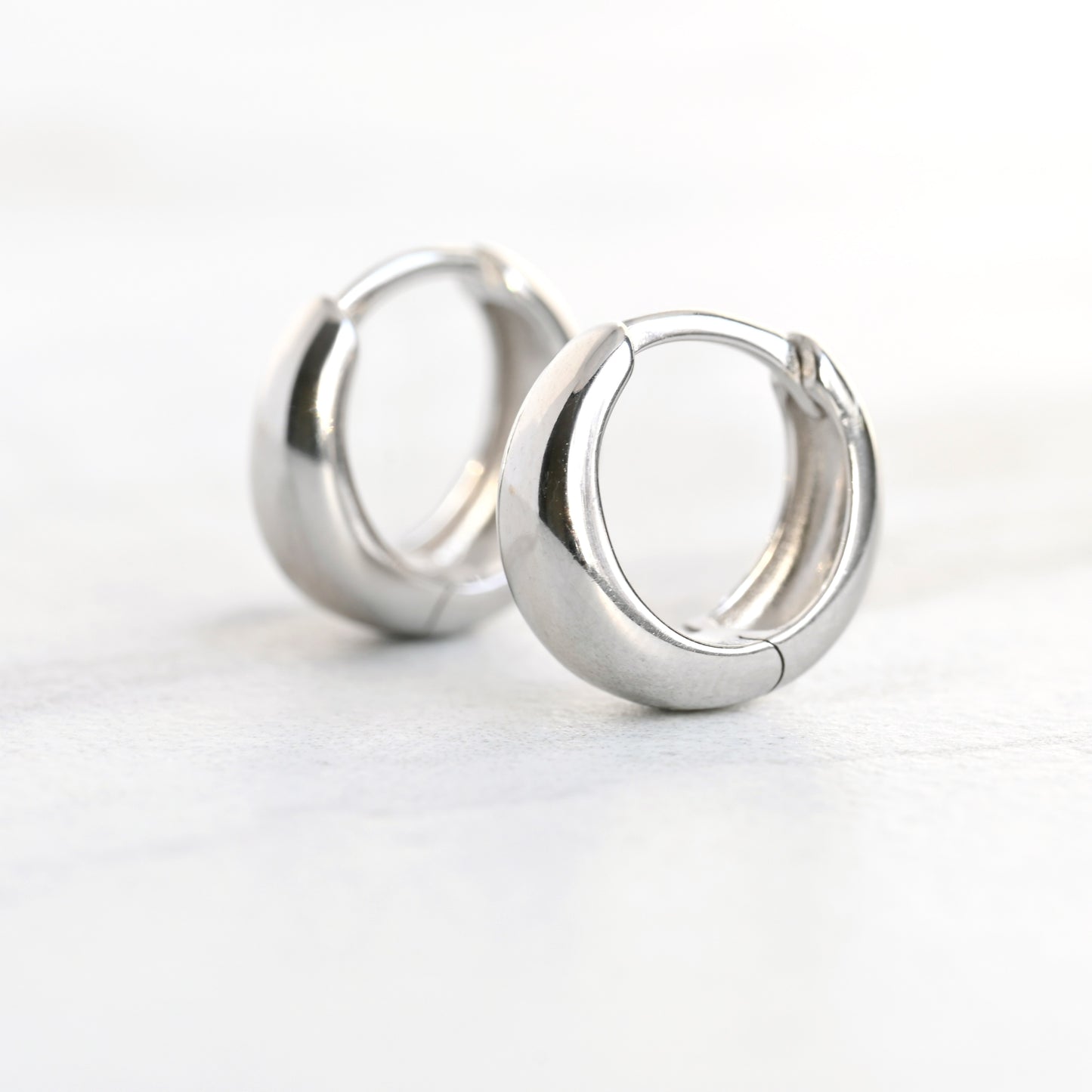 Pair of silver hoop earrings on a white background