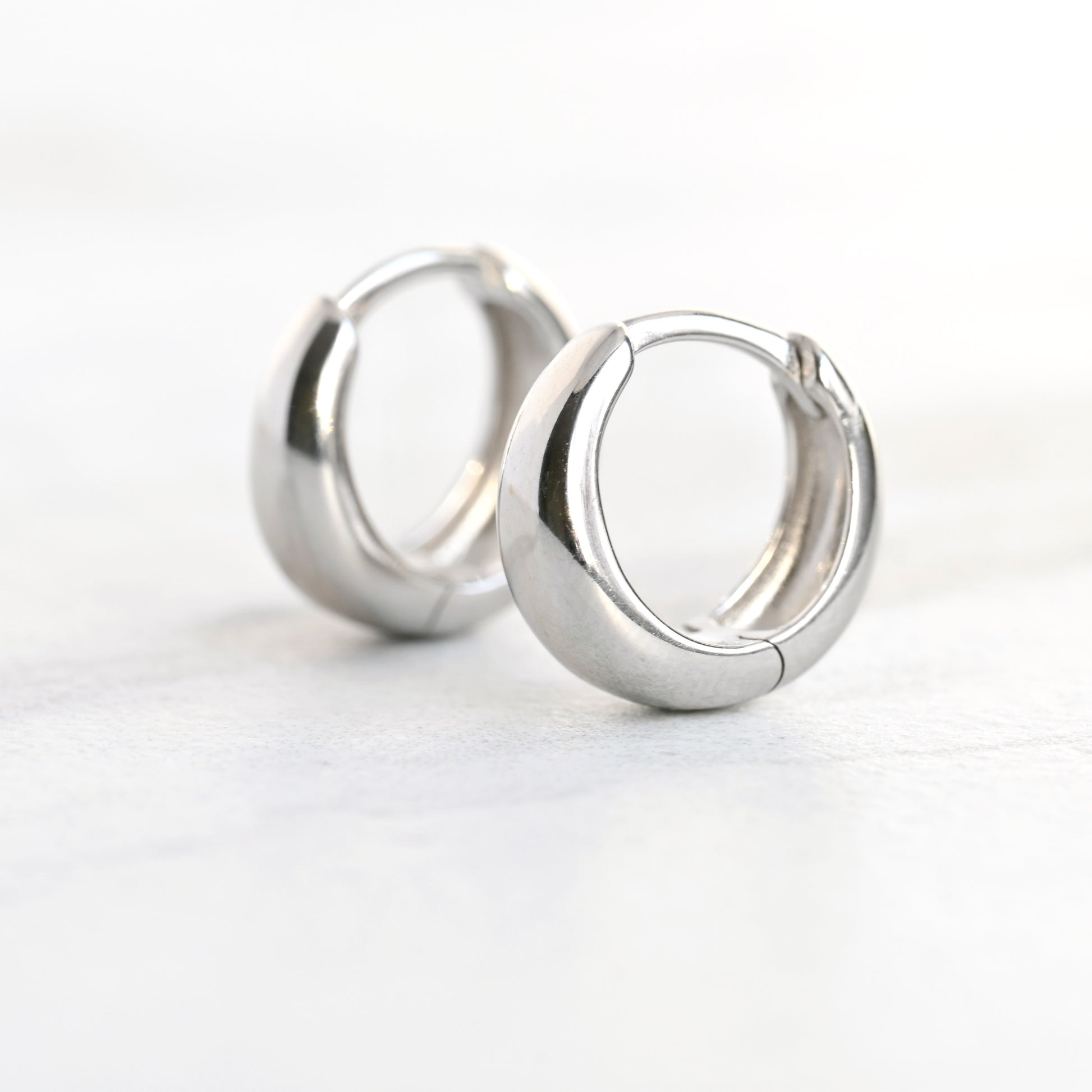 Pair of silver hoop earrings on a white background