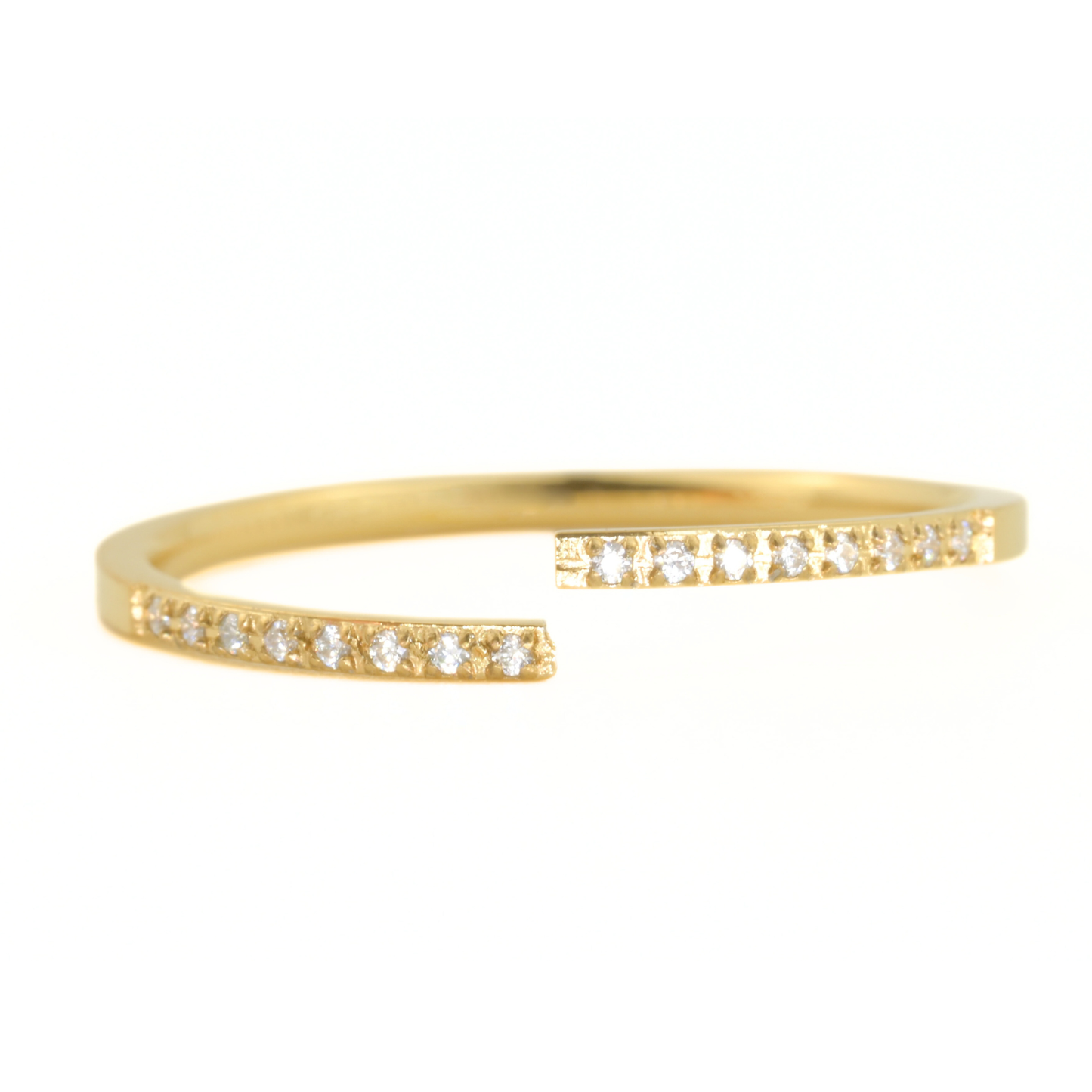 Gold cuff ring with small diamonds on a white background