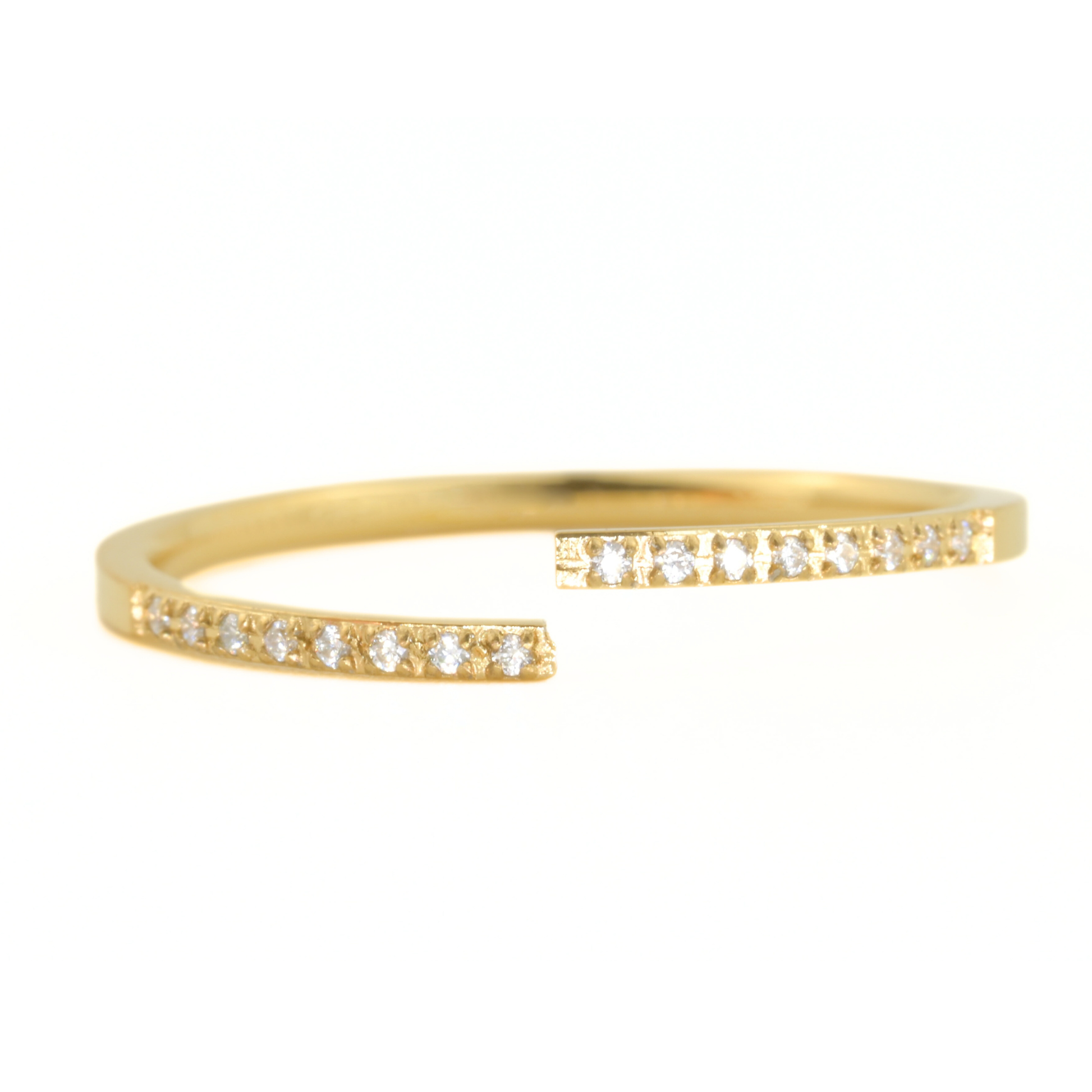 Gold cuff ring with small diamonds on a white background