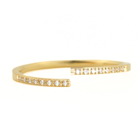 Gold cuff ring with small diamonds on a white background