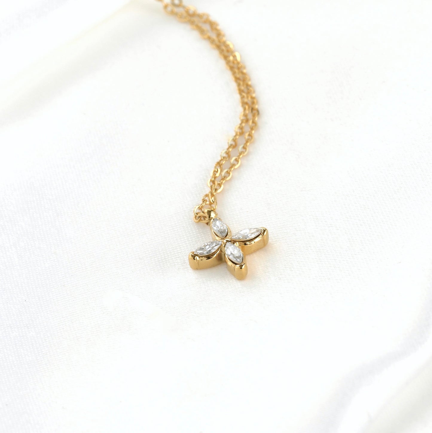 Gold necklace with a marquise pendant  and delicate cable chain on a white background