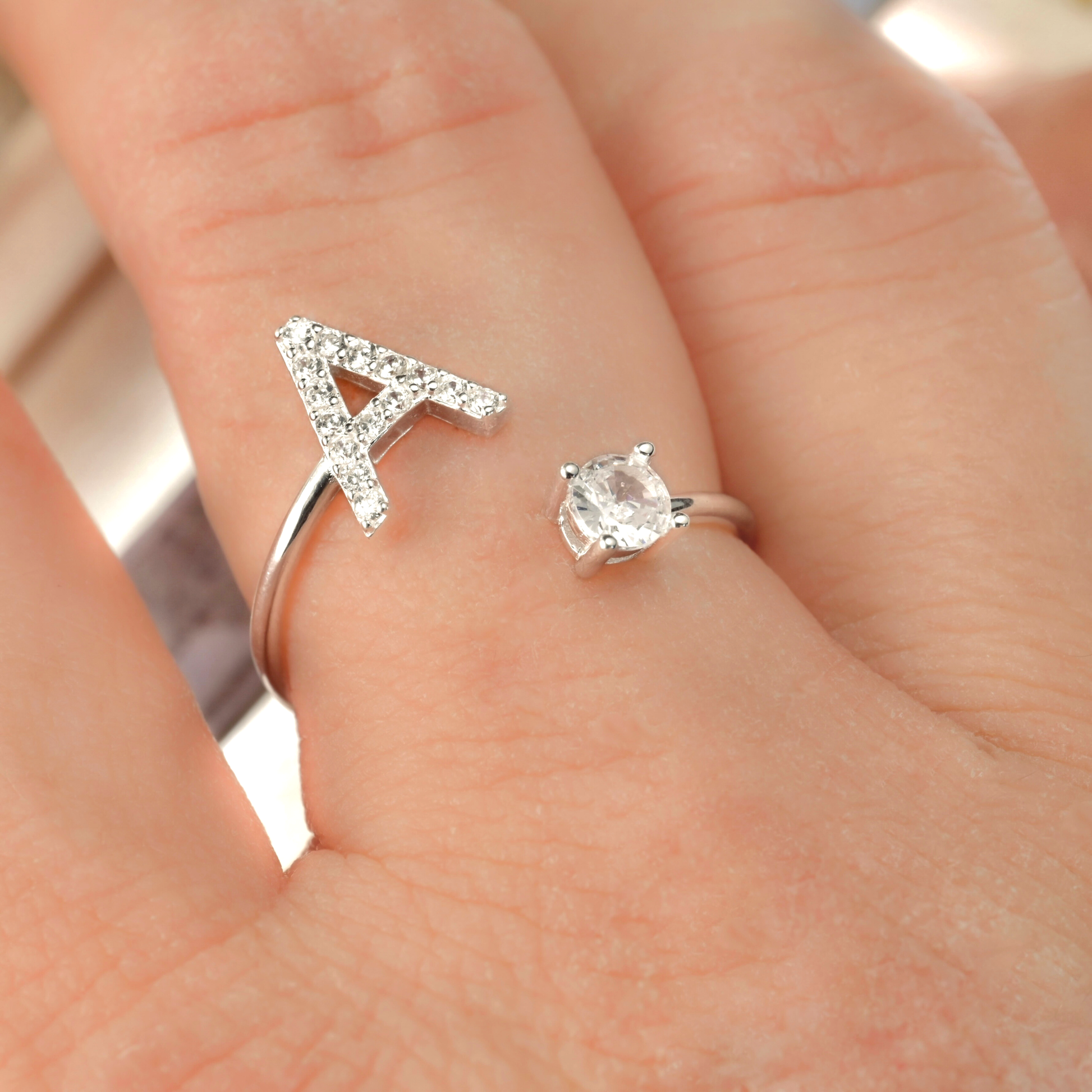 Silver ring with letter 'A' and diamond on a hand