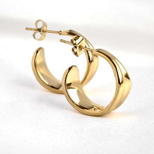 Medium sized gold C hoop earrings on a white background