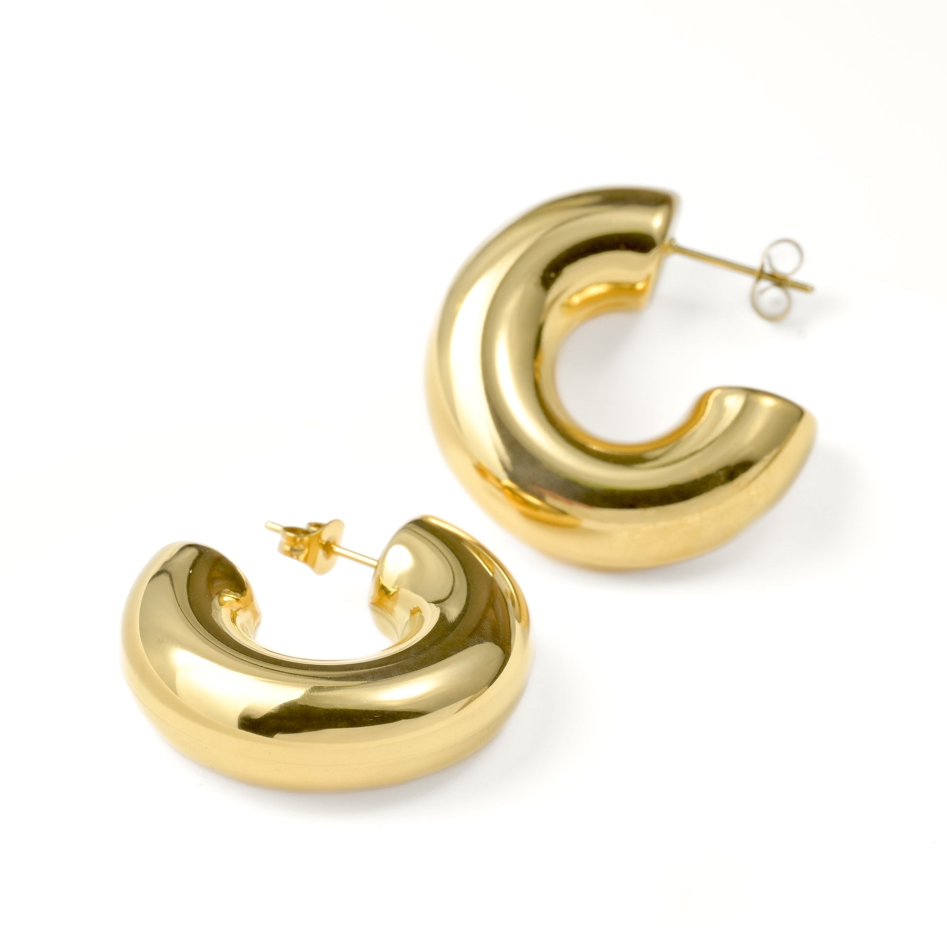 Chunky gold hoop earrings on a white background
