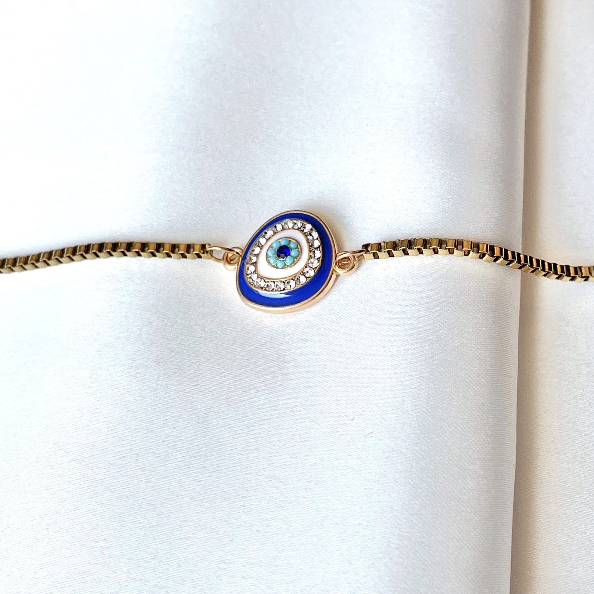 Ankle bracelet with a blue evil eye design on a white background