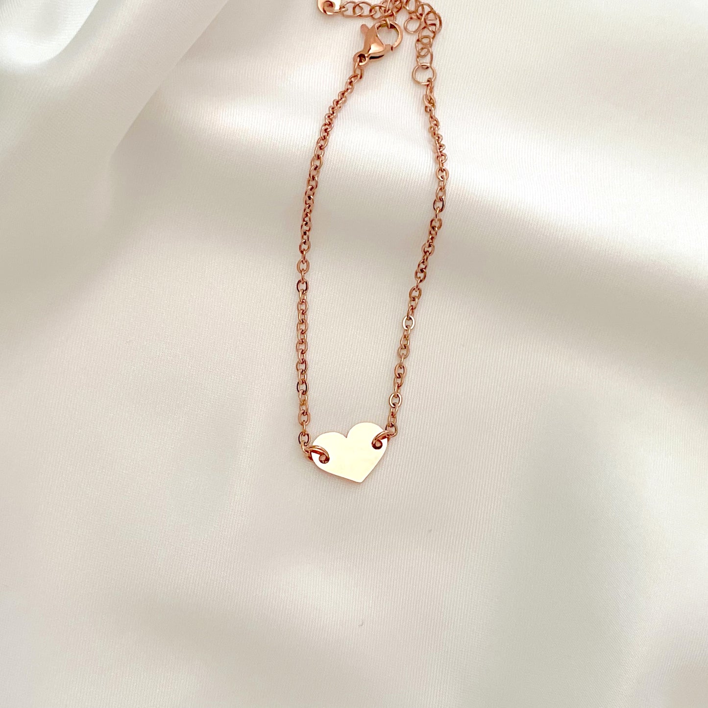 Rose gold heart bracelet on a light background
