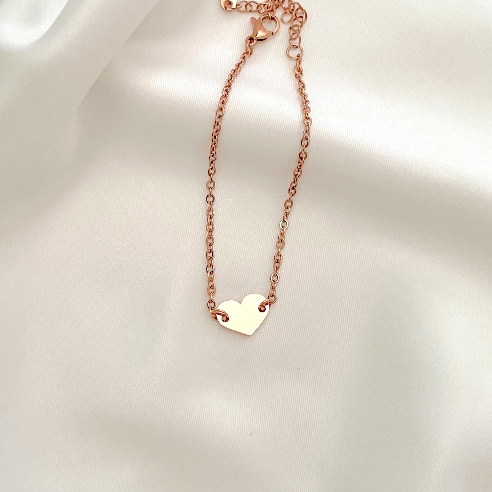 Rose gold heart bracelet on a light background