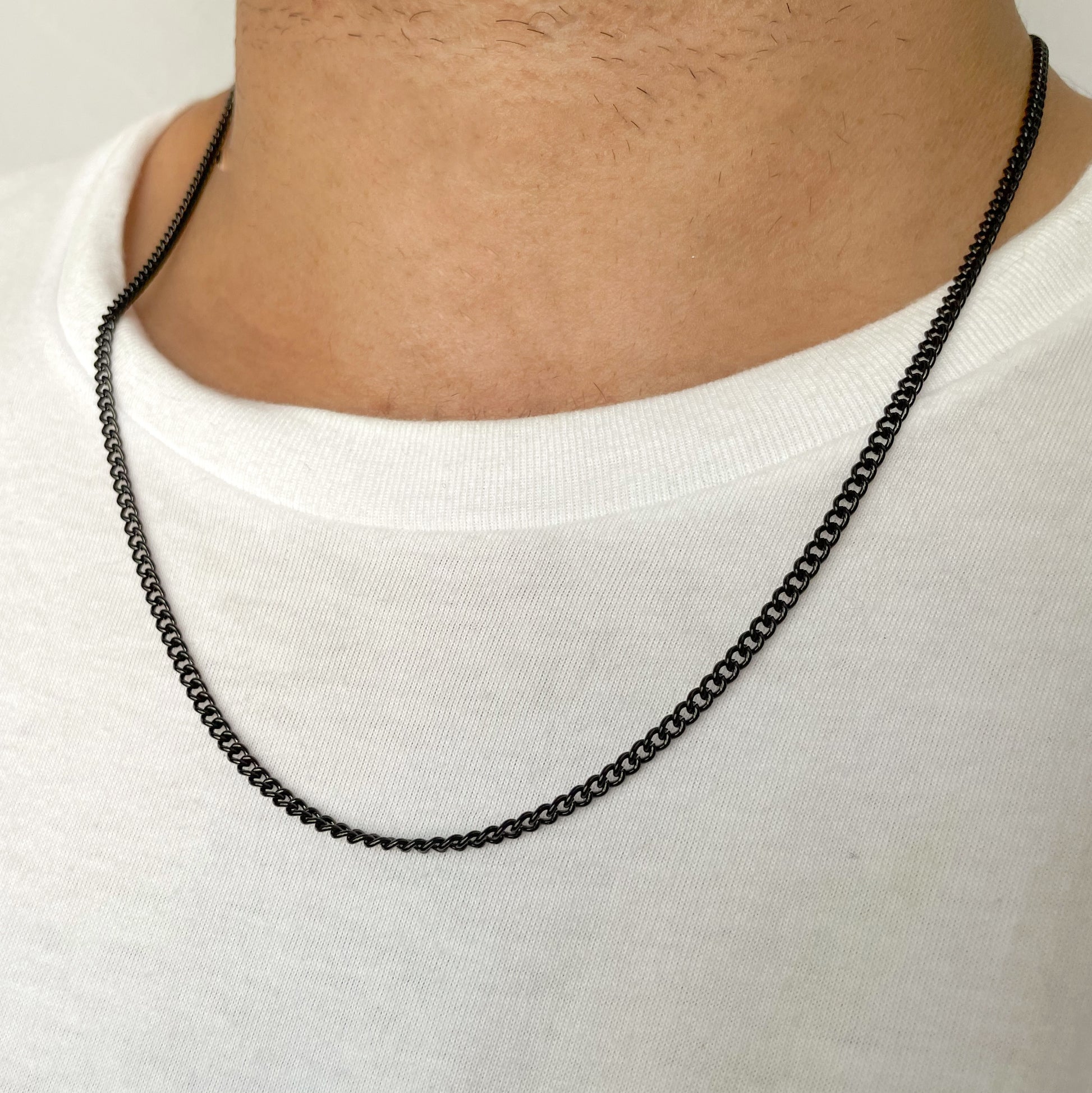 Black chain necklace on a man wearing a white shirt
