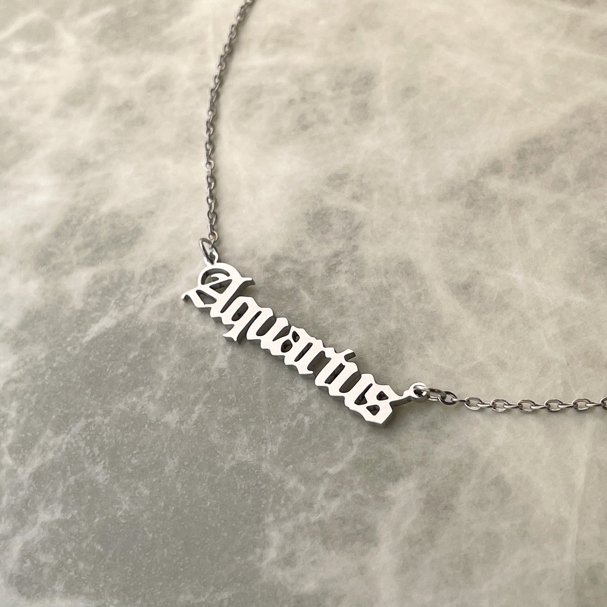 Silver 'Aquarius' necklace on a marble surface