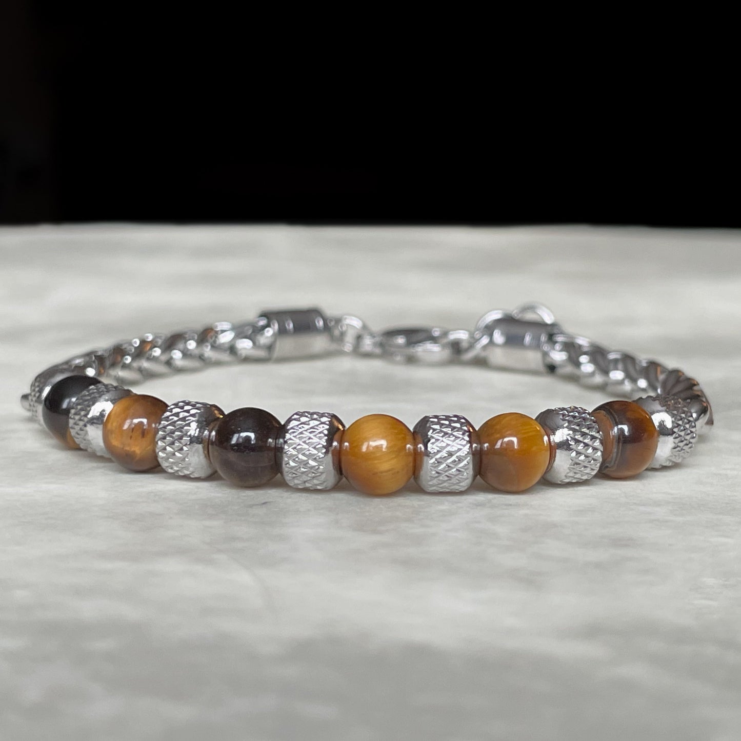Bracelet with brown and silver beads on a textured surface