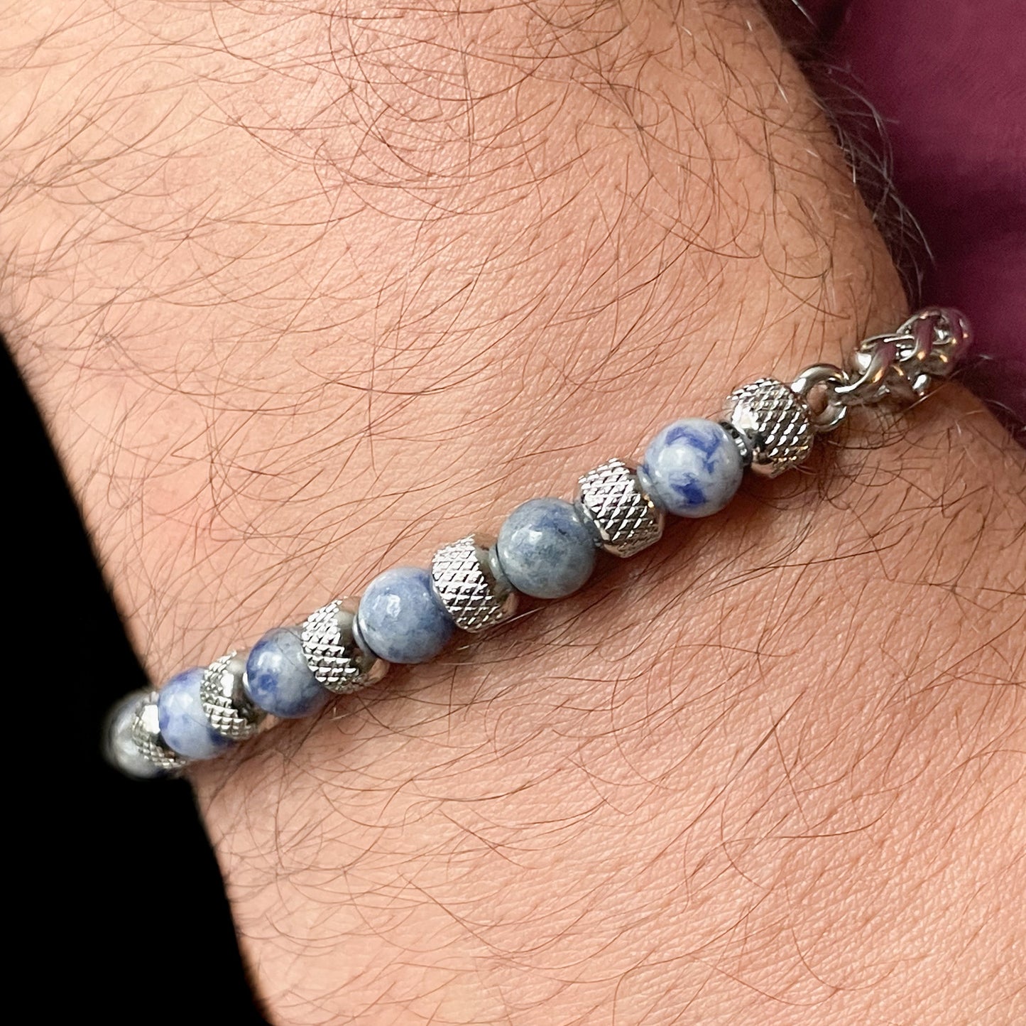 Close-up view of. bracelet with sodalite beads and silver accents on a man's wrist