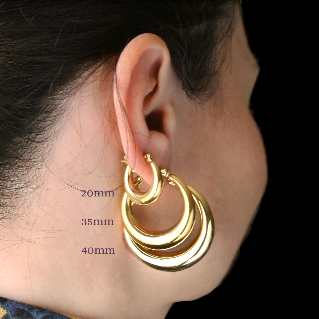 Gold hoop earrings worn on an ear with size measurements indicated.