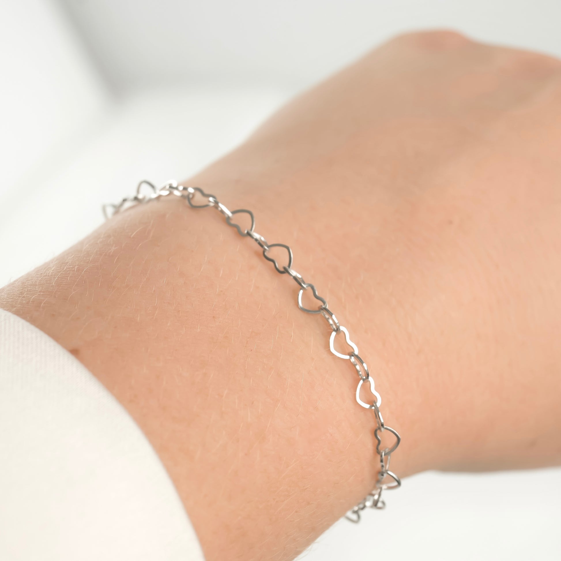 925 Silver heart chain bracelet in natural silver finish on a wrist against a white background.
