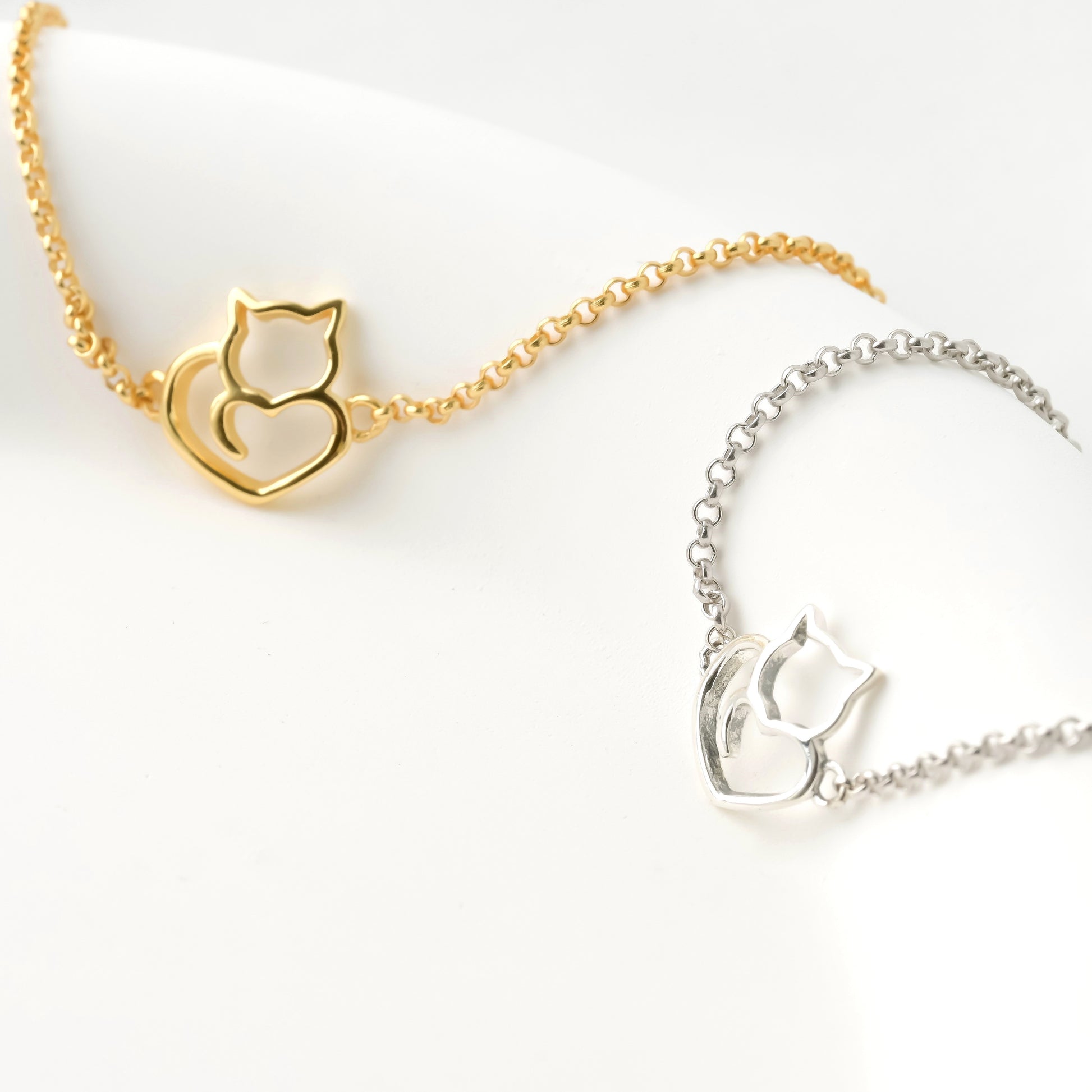 Gold and silver cat-shaped bracelets on a white background