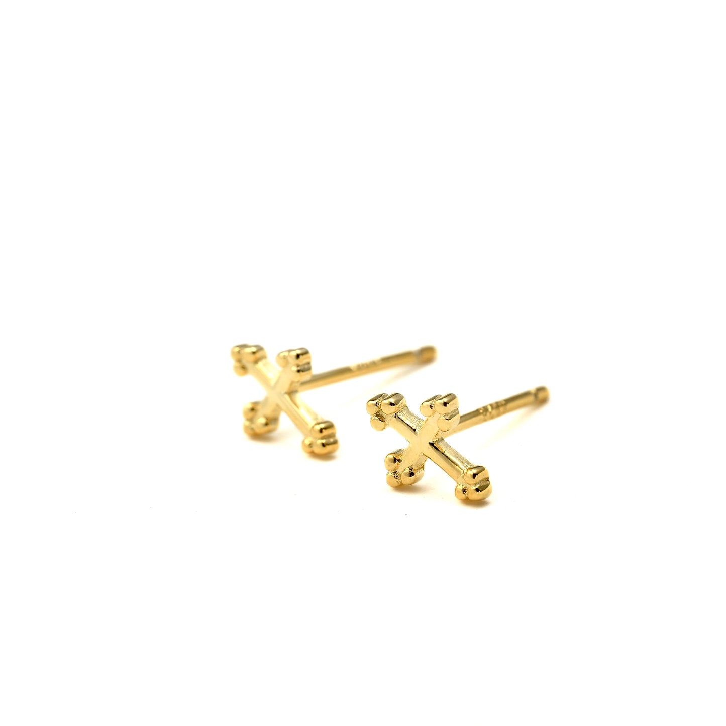 Small gold cross stud earrings on a white background