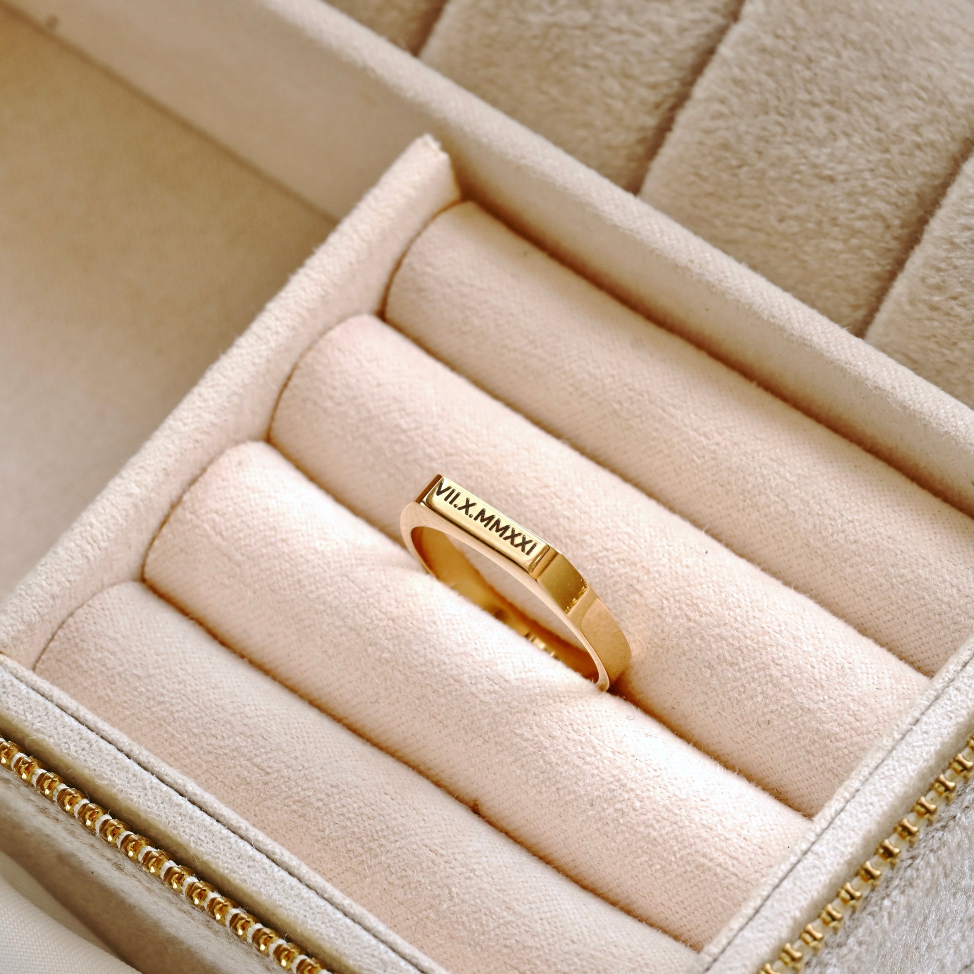 Engraved gold signet ring in a ring tray