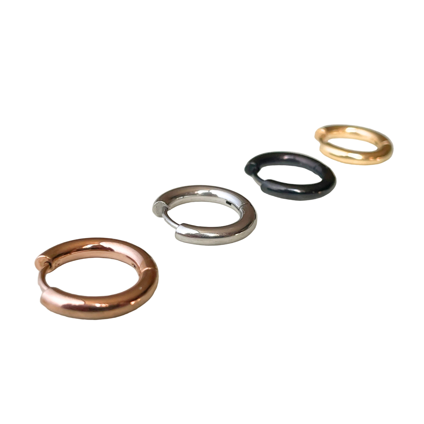 Set of five stainless steel hoops in different colors on a white background