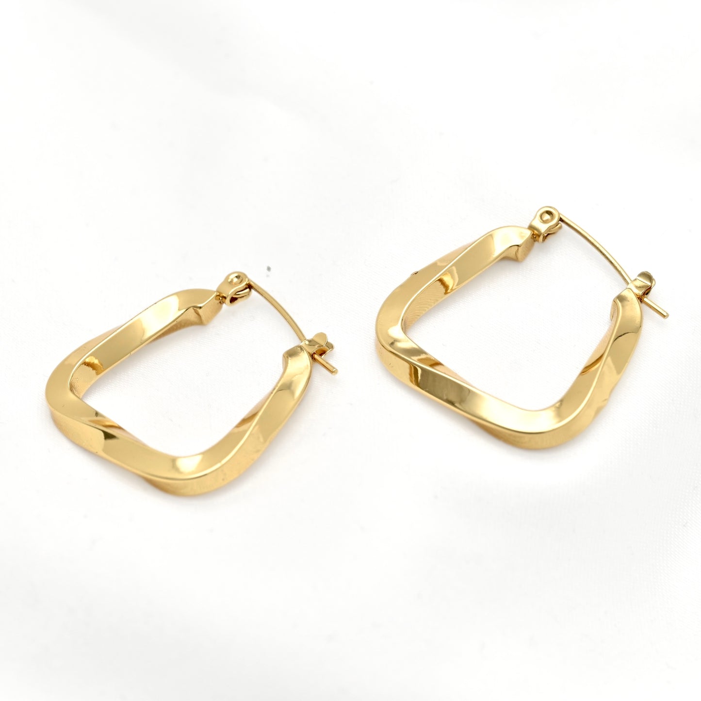 A pair of gold-tone square hoop earrings with a polished, slightly wavy textured finish, displayed on a clean white background.
