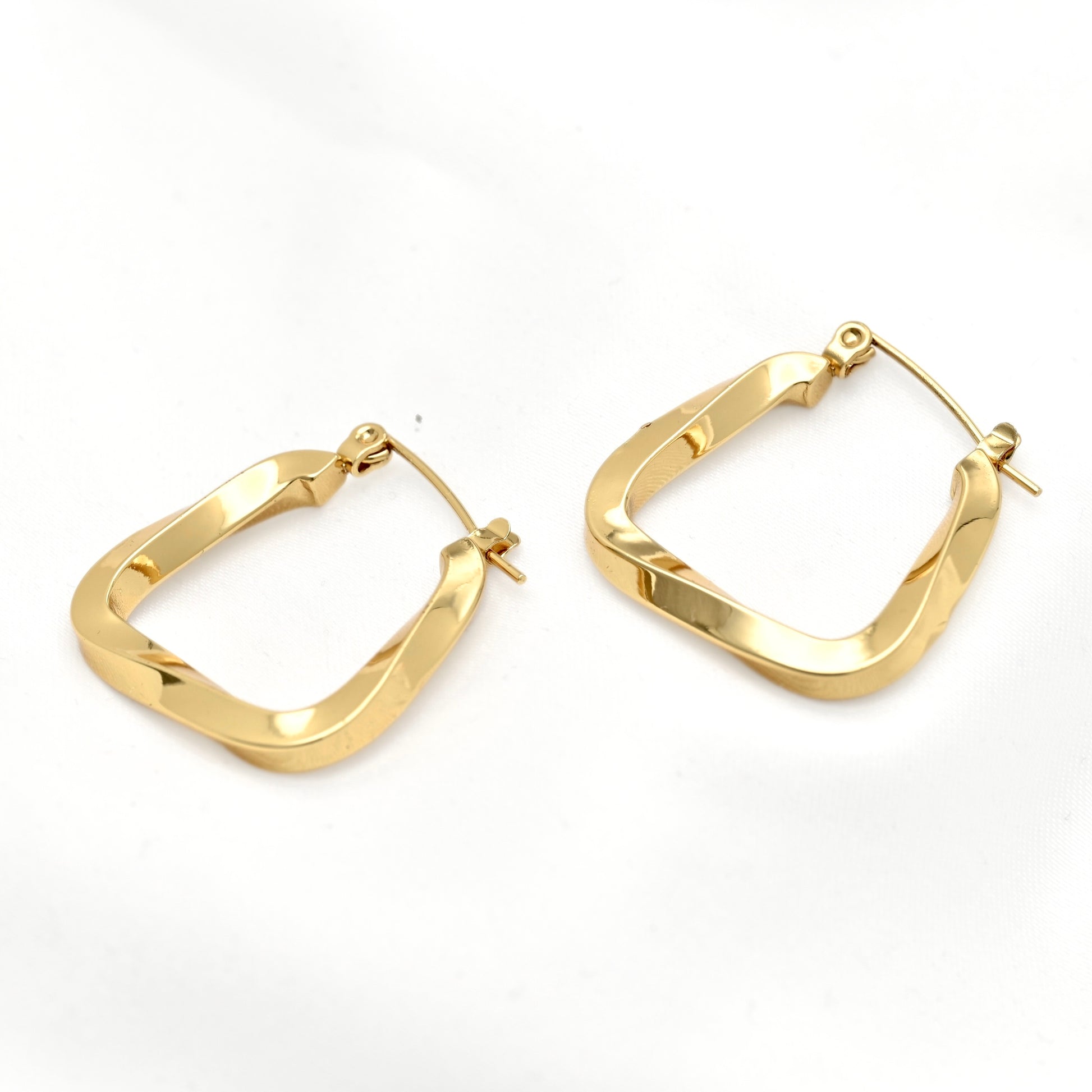 A pair of gold-tone square hoop earrings with a polished, slightly wavy textured finish, displayed on a clean white background.