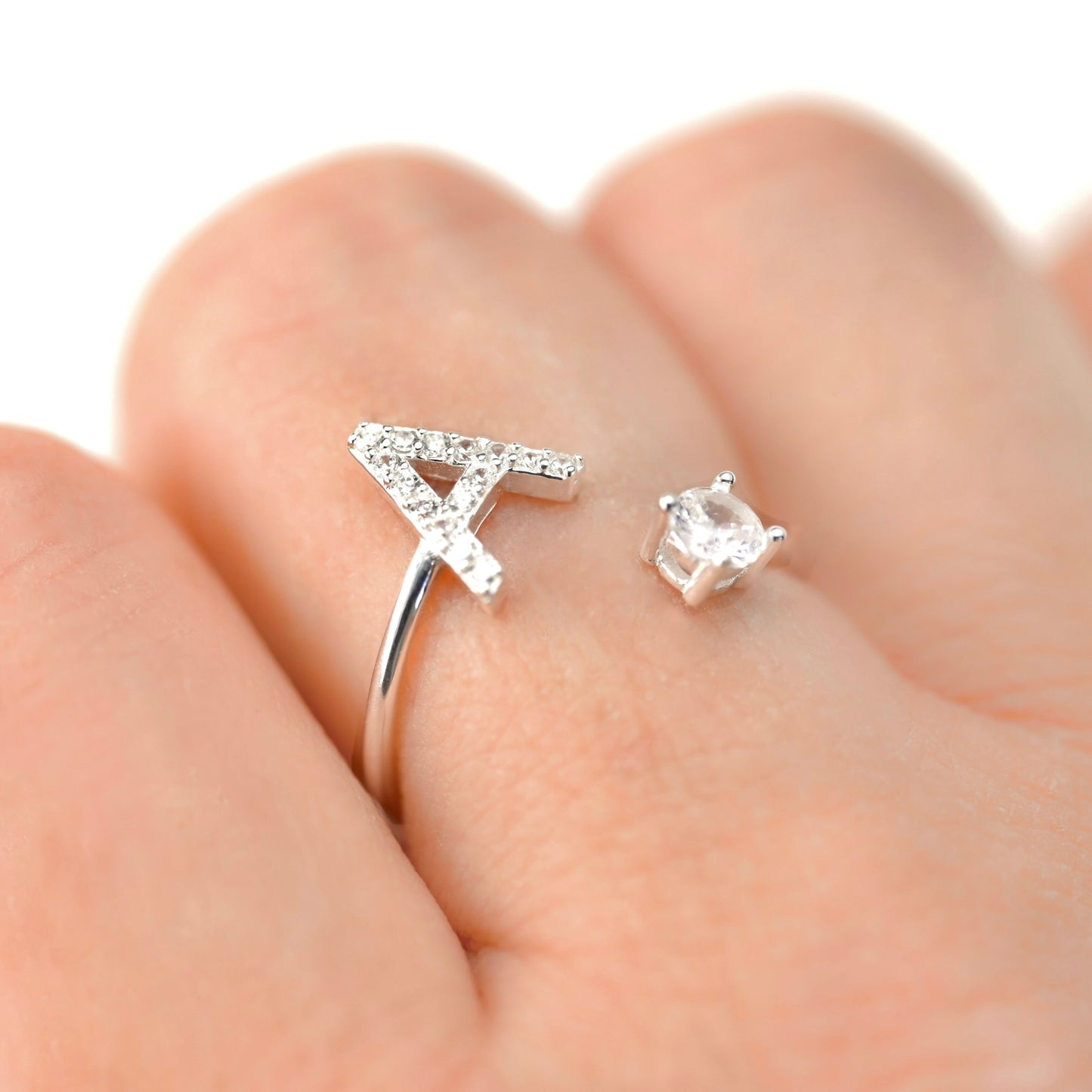 Silver open ring with initial 'A' and  a round CZ on the other end on a finger 