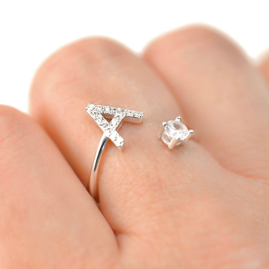 Silver open ring with initial 'A' and  a round CZ on the other end on a finger 