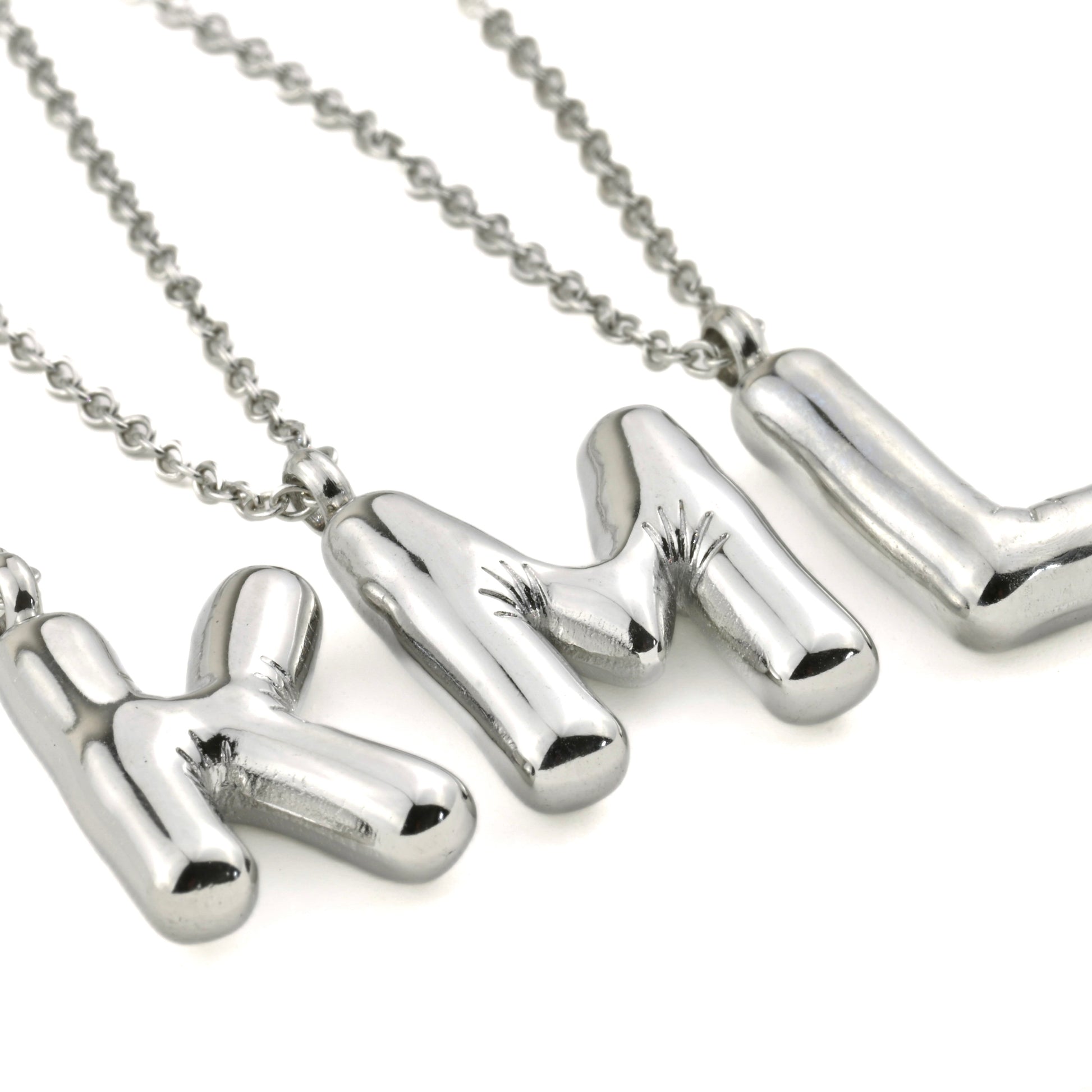 Silver molten initial necklace with letter 'K' ,'L''and M' pendants on a white background