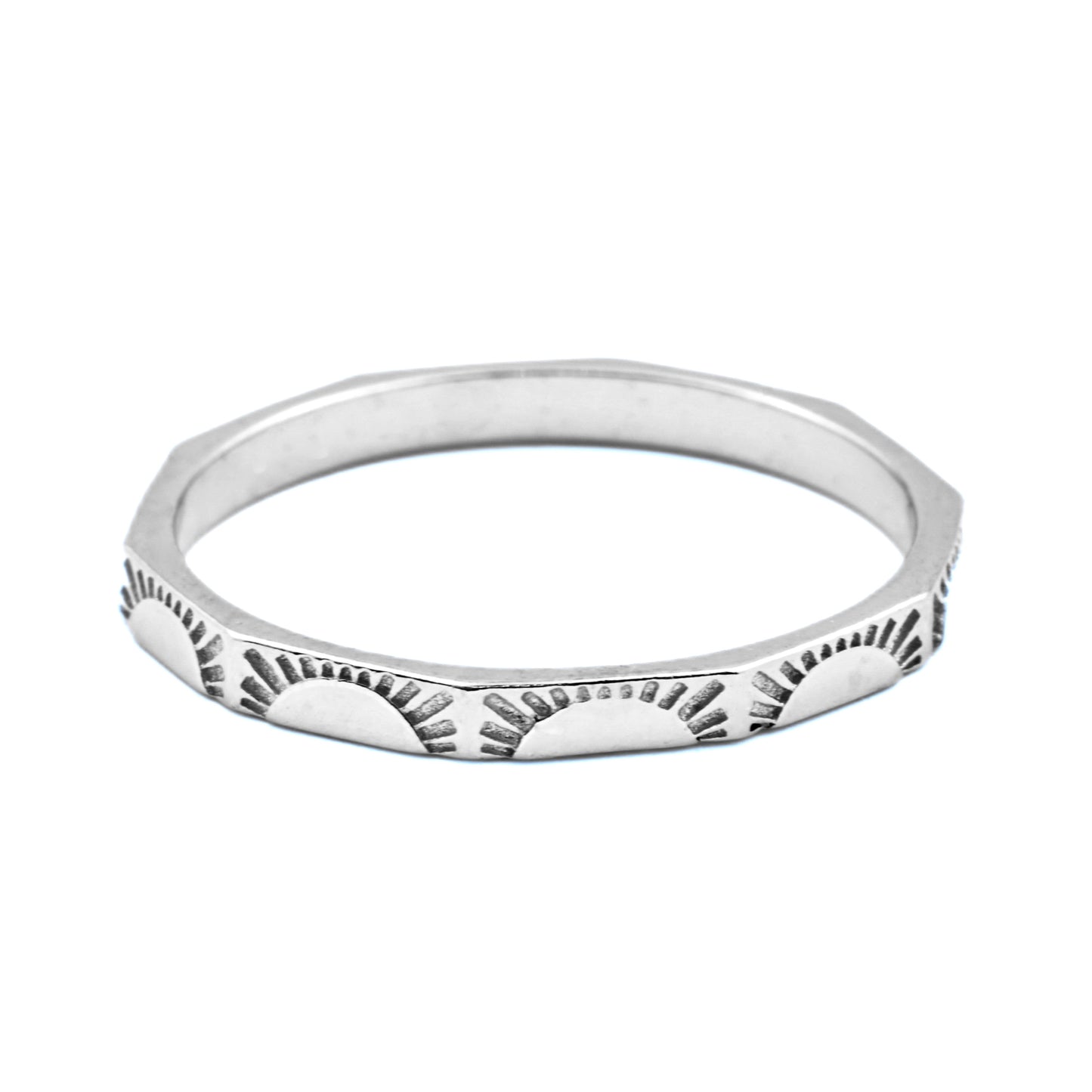 Angular silver sunburst  ring with a textured design on a white background