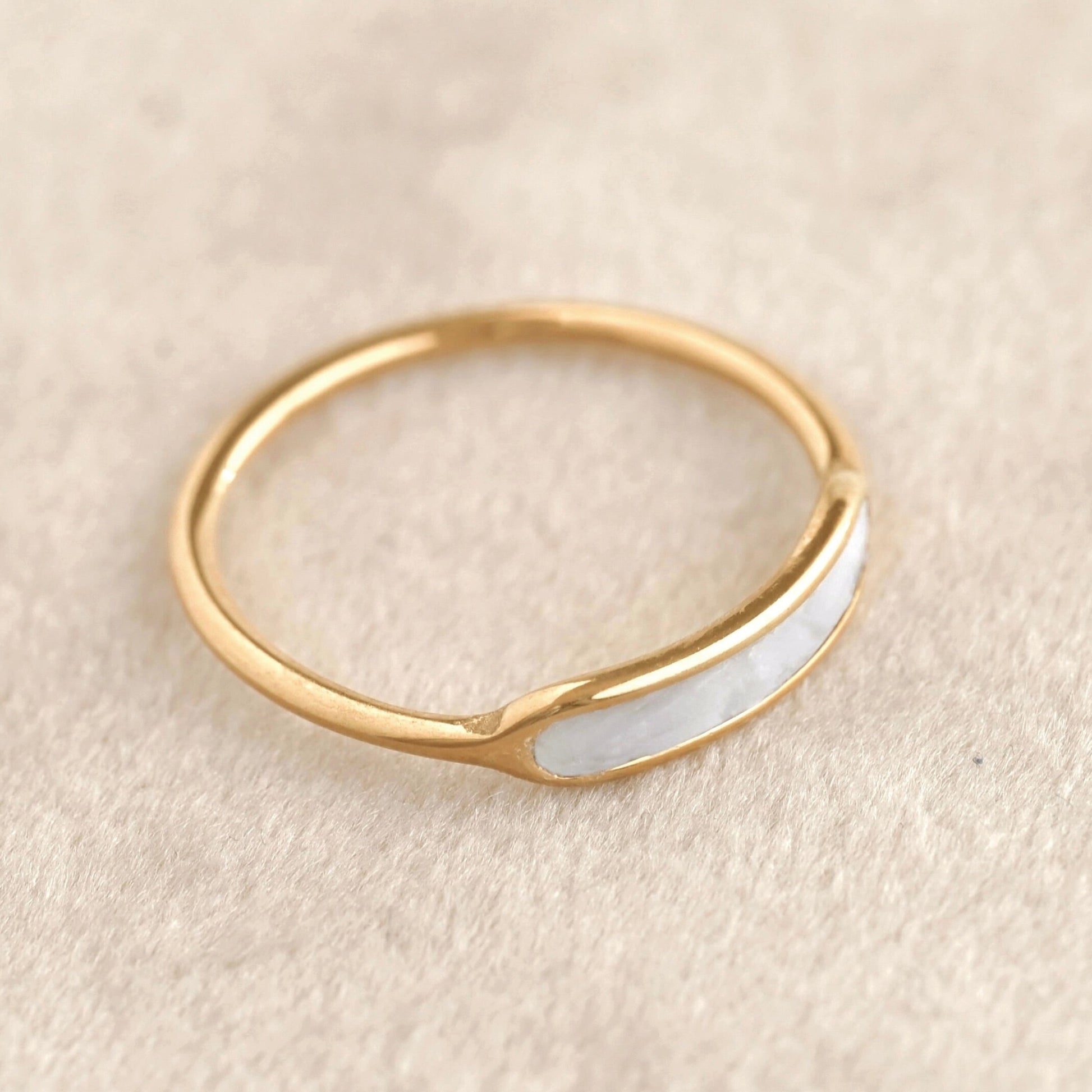 Waterproof gold ring with a shell inlay on a beige background