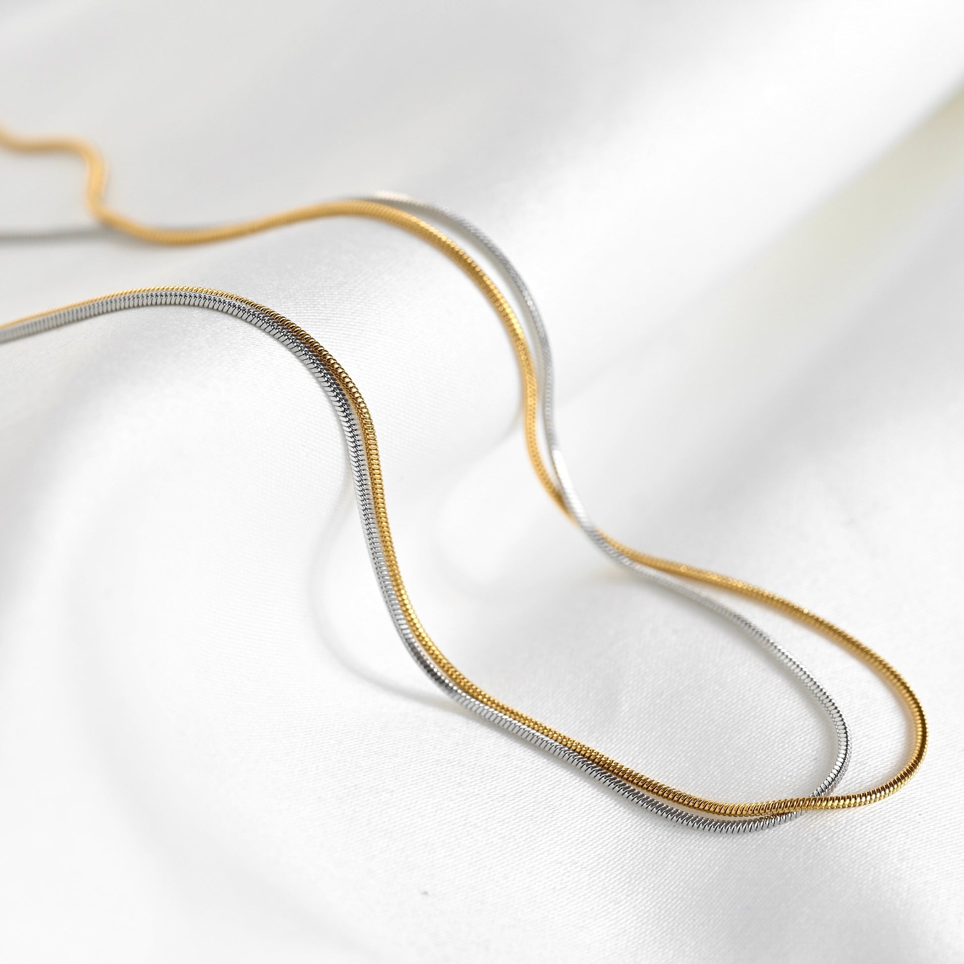 Two-tone snake necklace on a white background