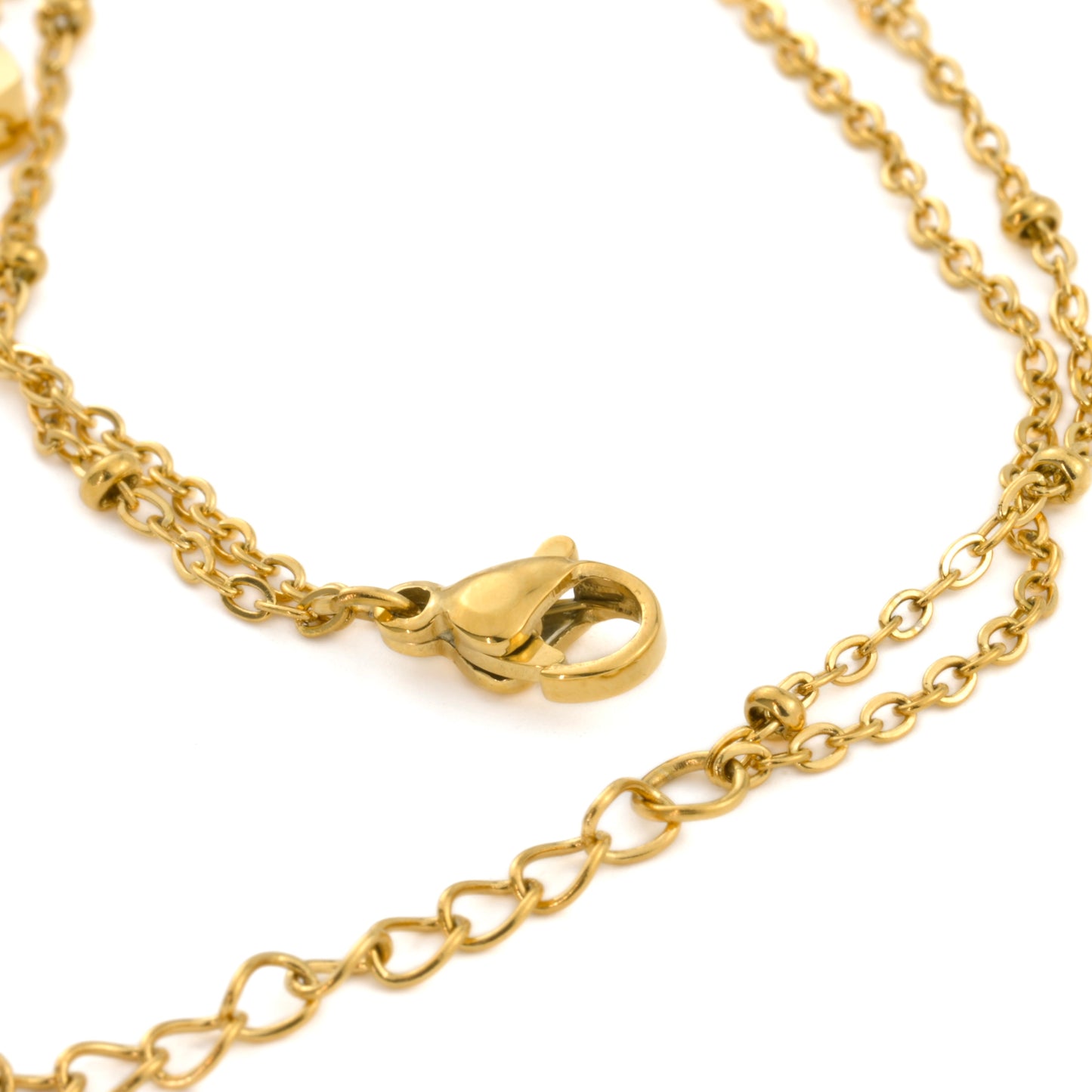 Close-up view of the clasp area of gold heart anklet showing the cable and satellite chains linked on a single lobster claw clasp and extender