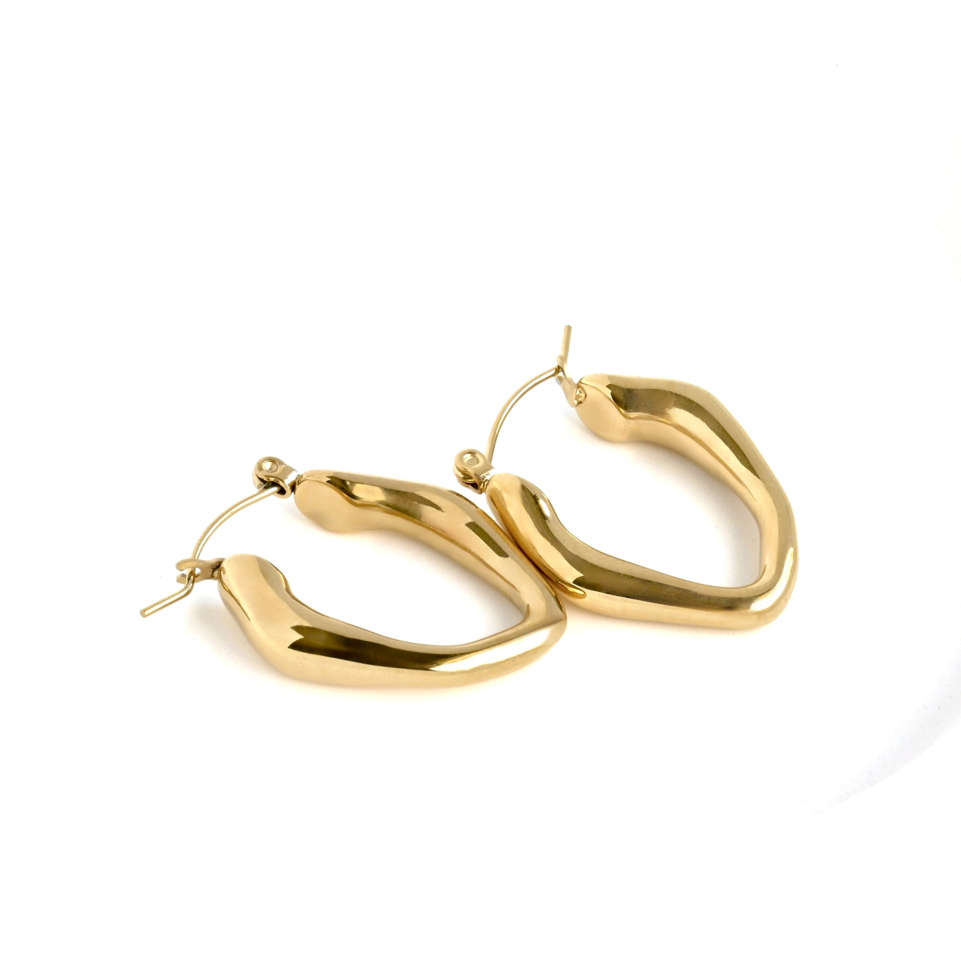 close-up of organic molten gold hoop earrings on a white background