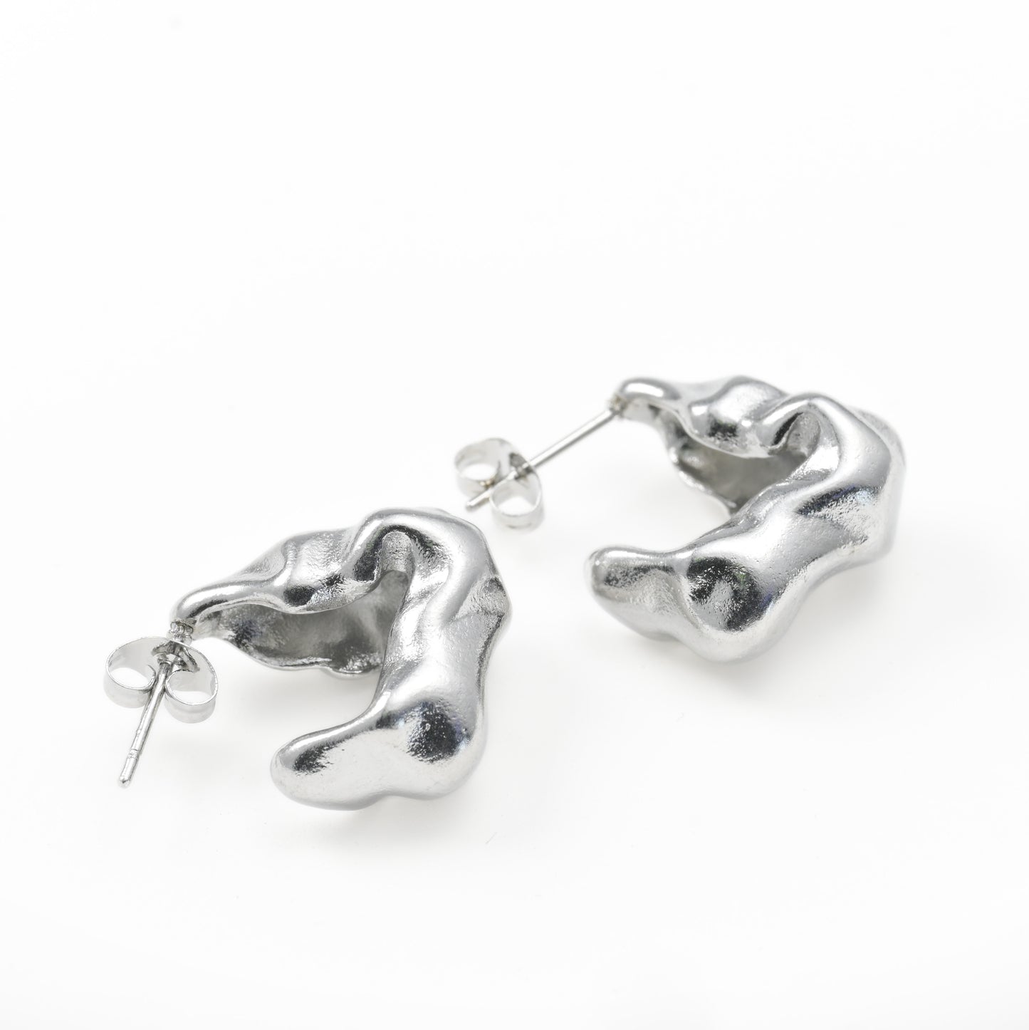 silver figure earrings on a white surface