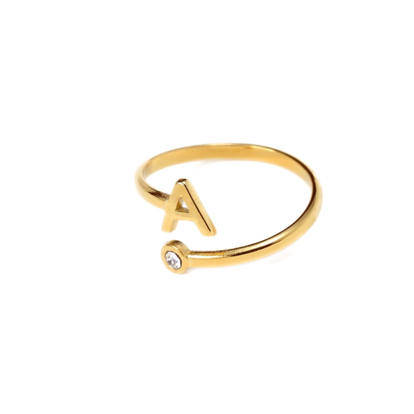 Gold ring with letter 'A' and small gemstone on a white background