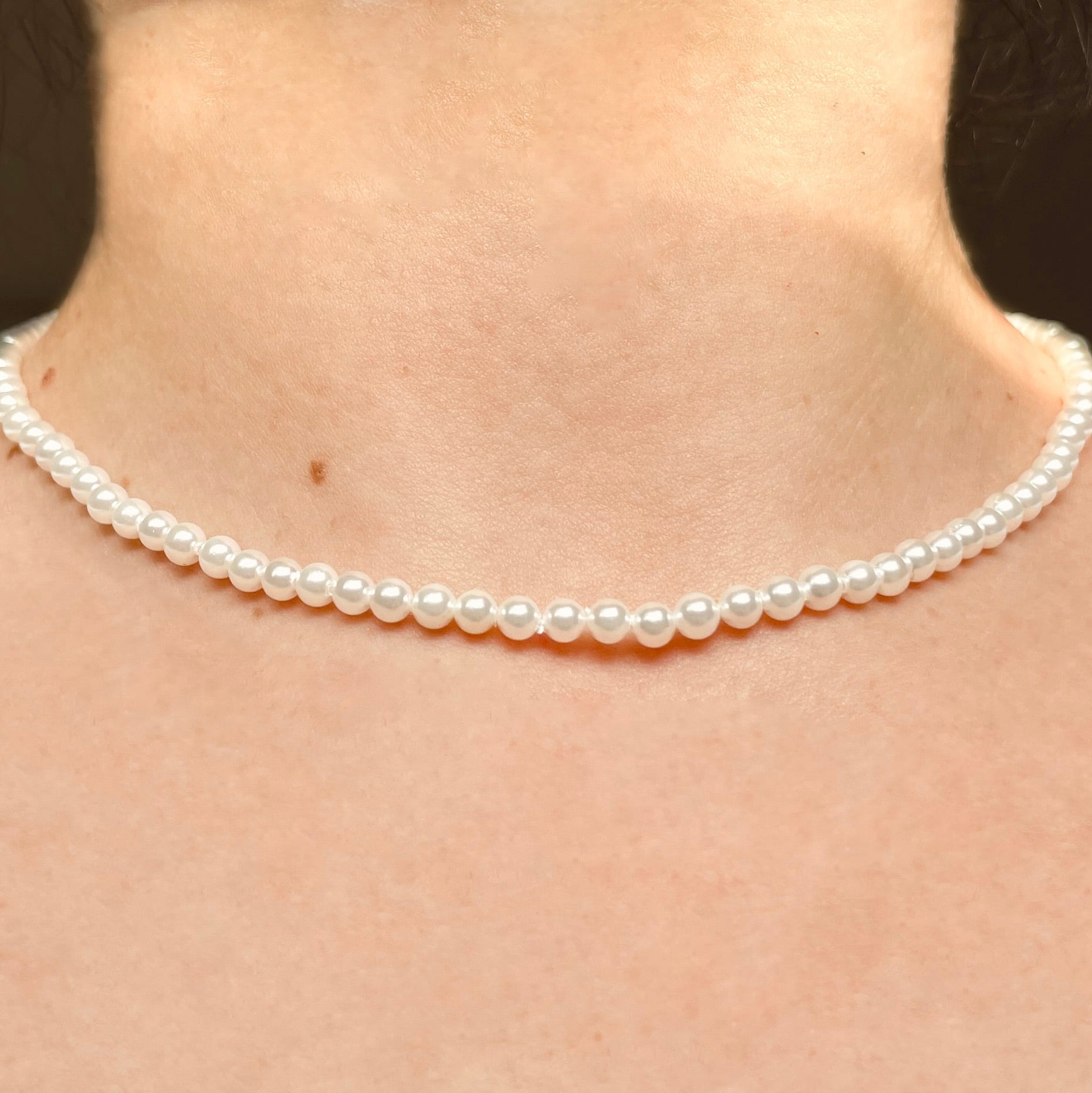 16-inch pearl necklace with 4mm pearls worn by a person with a neutral background 
