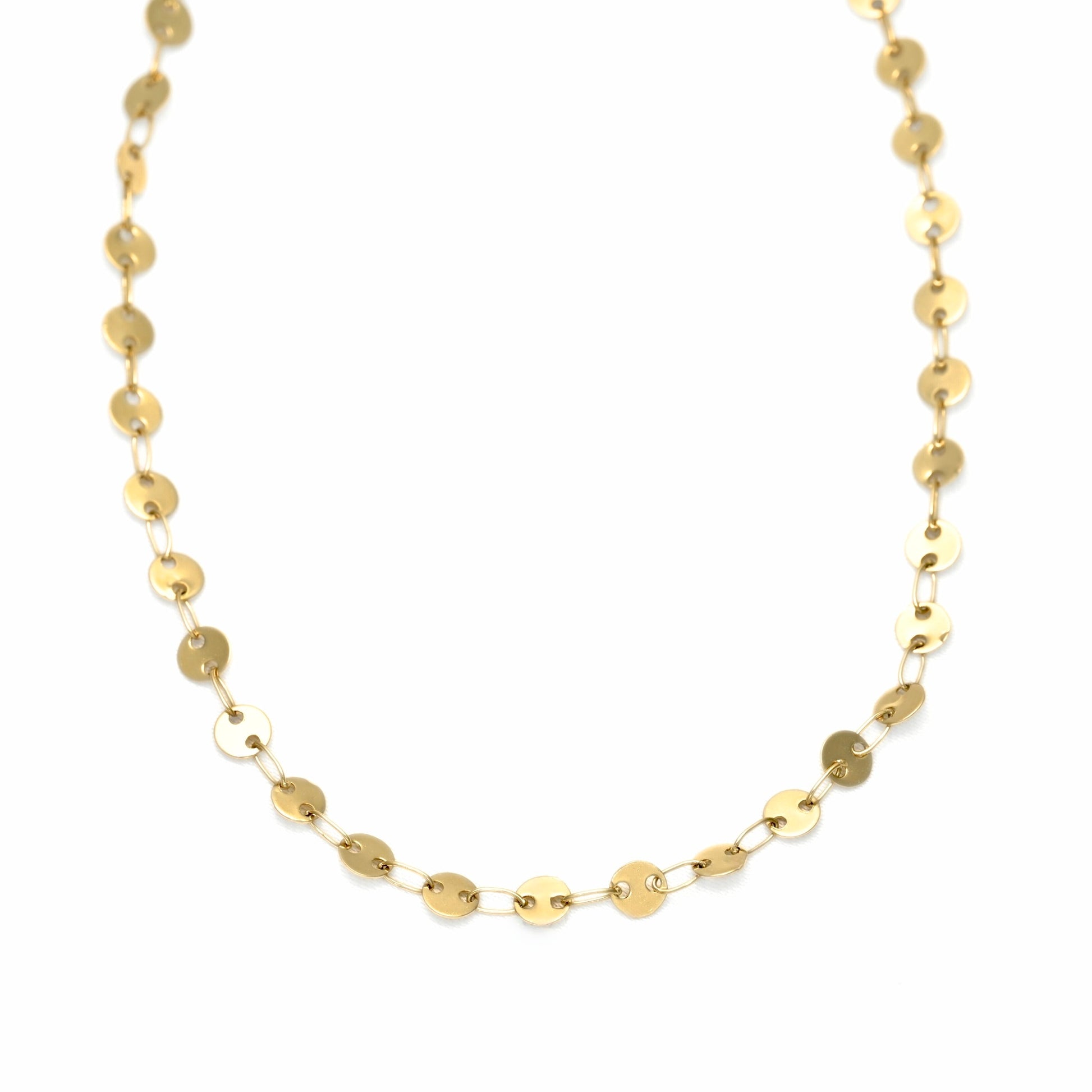 A delicate gold chain necklace composed of small, flat, disc-like links, displayed against a solid white background.