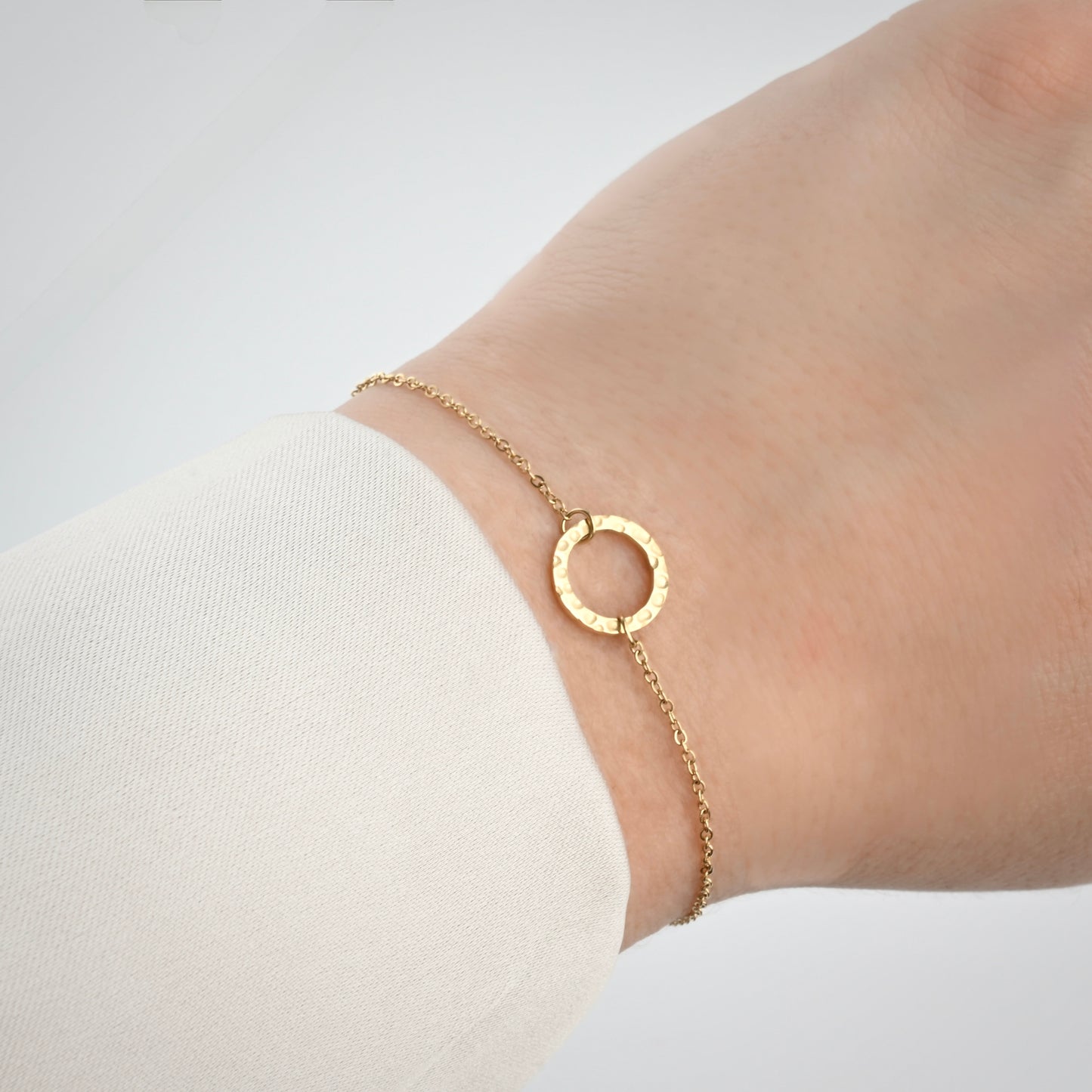 Gold bracelet with medium size hammered circle link on a wrist