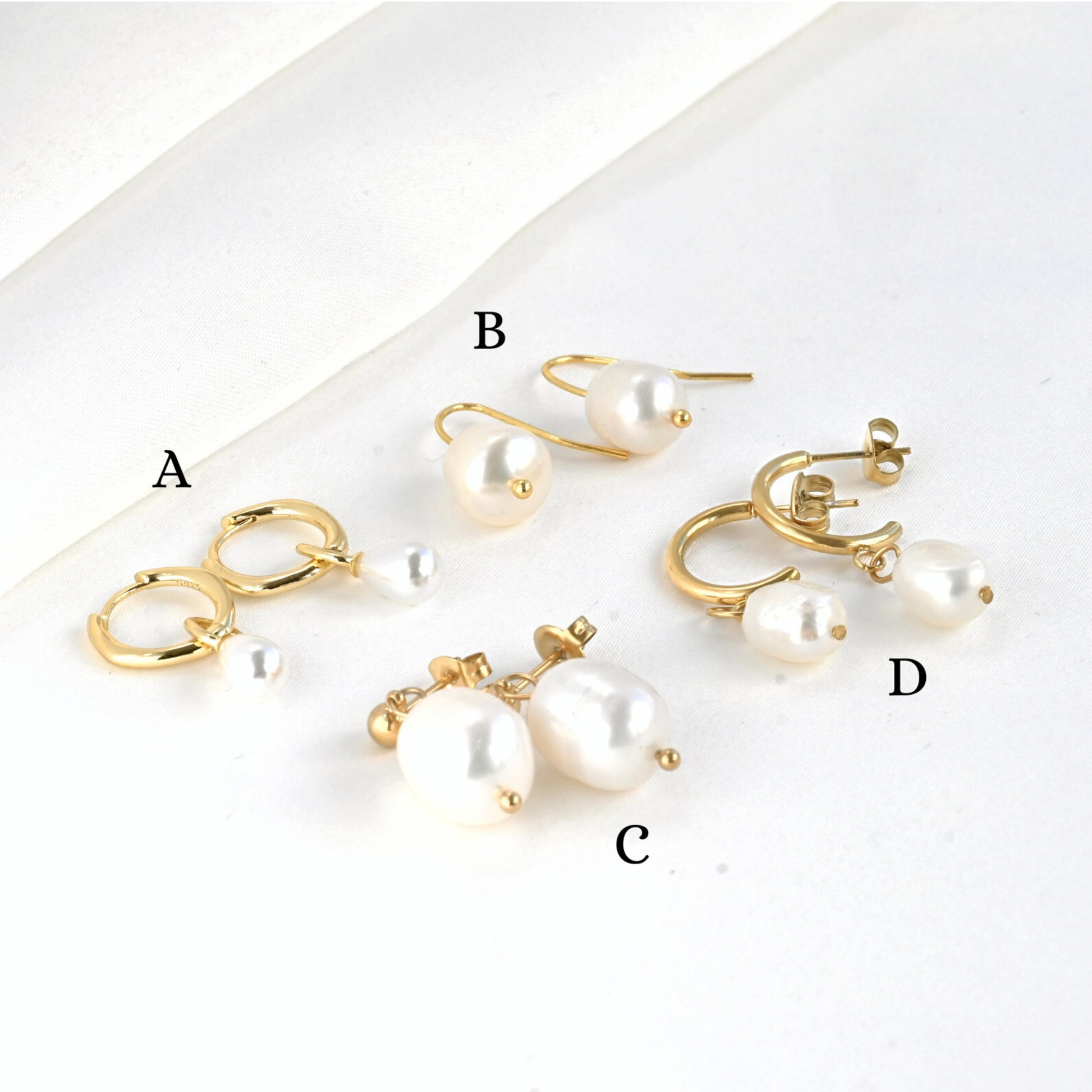 Set of pearl earrings with gold accents on a white background