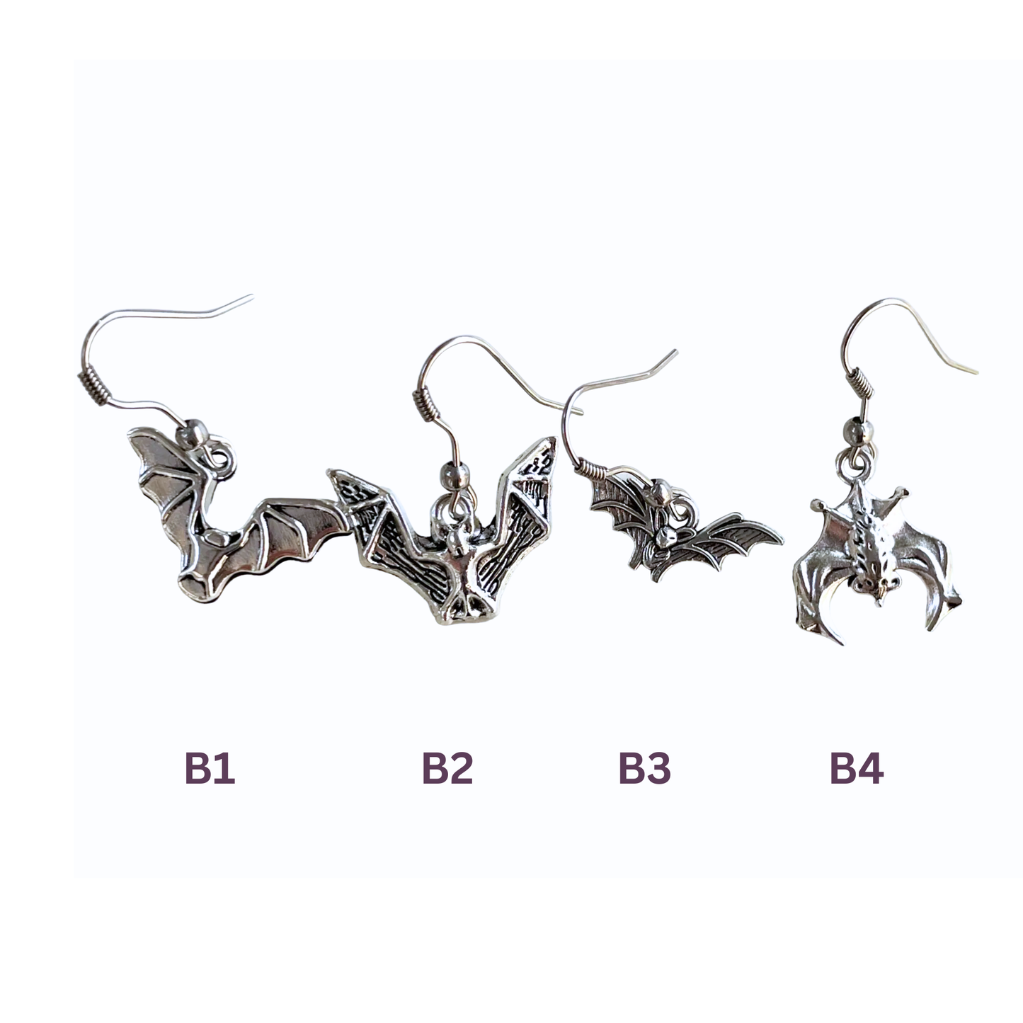 Set of bat-shaped earrings on a white background