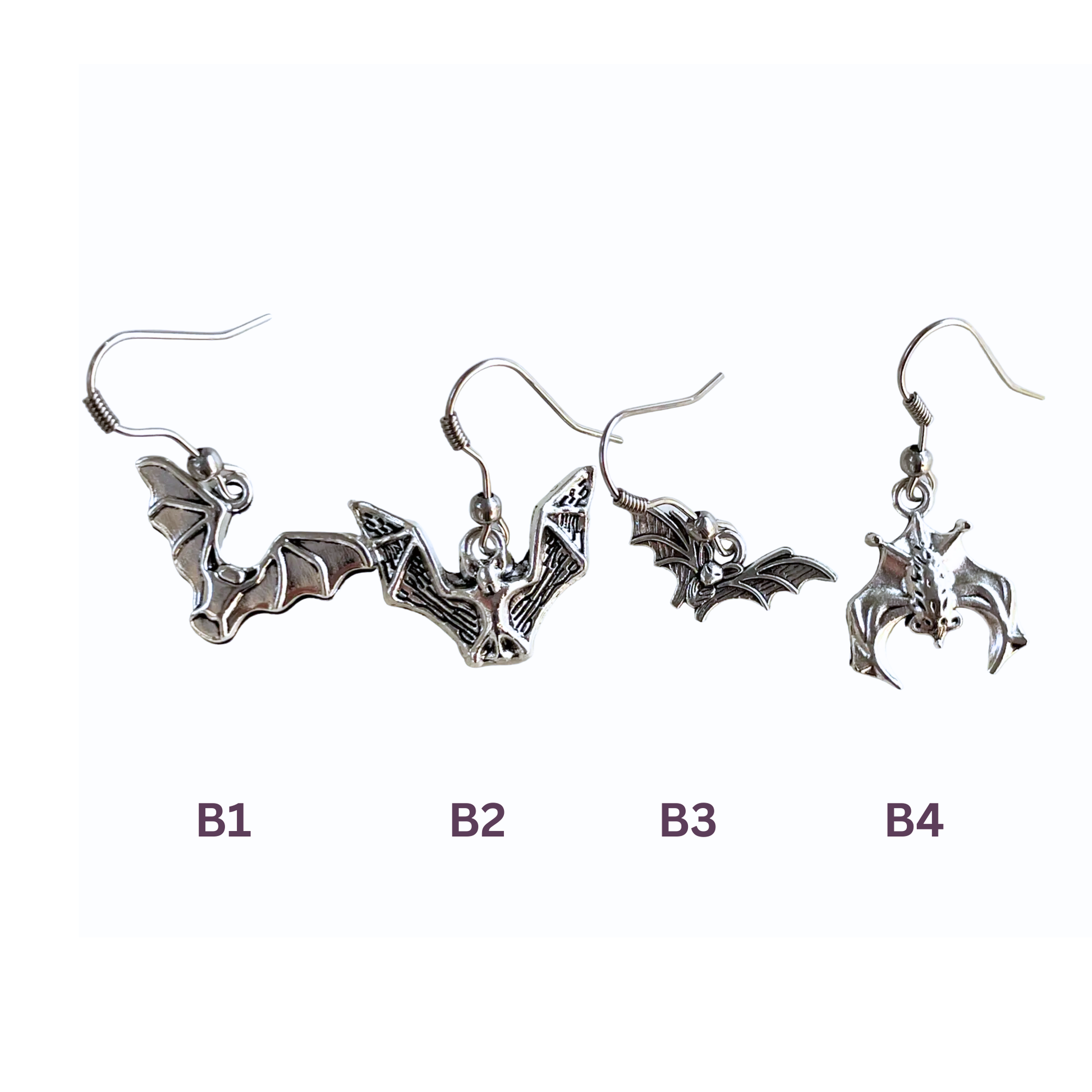 Set of bat-shaped earrings on a white background
